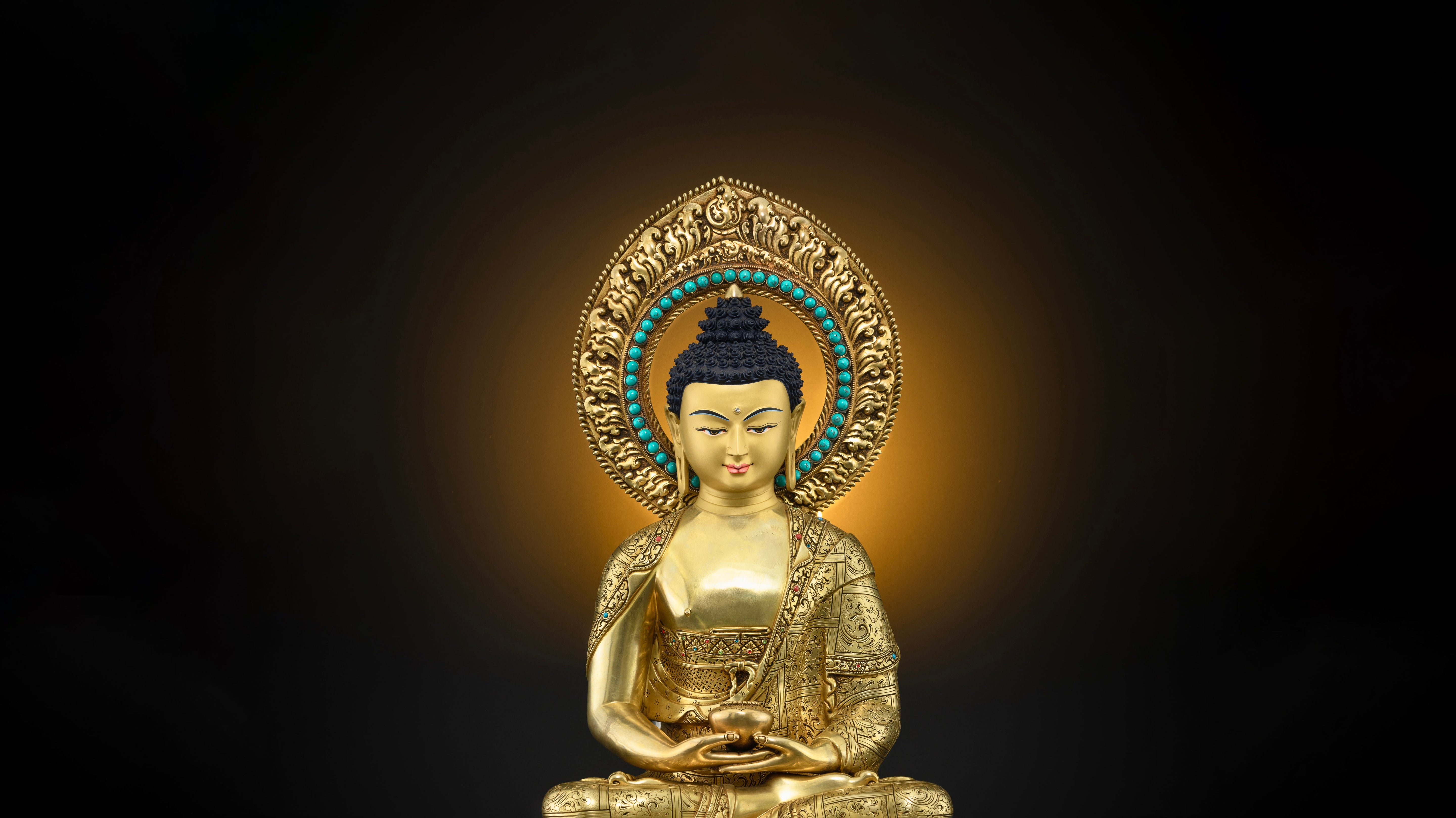 Gold statue of Amitabha Buddha with halo made on a copper base material sitting in a meditation posture