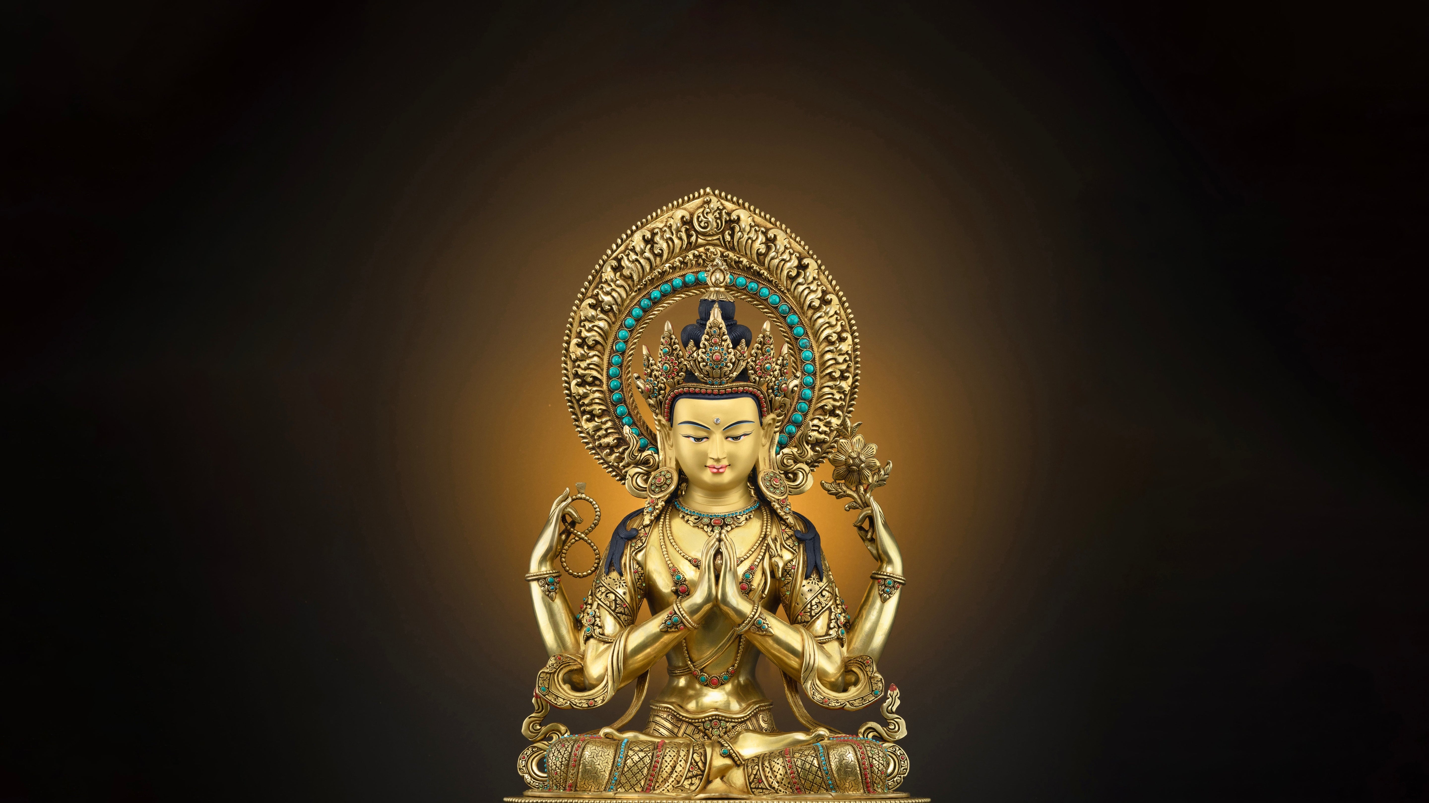 four armed golden Chenrezig statue in a state of meditation adorned with various gemstones
