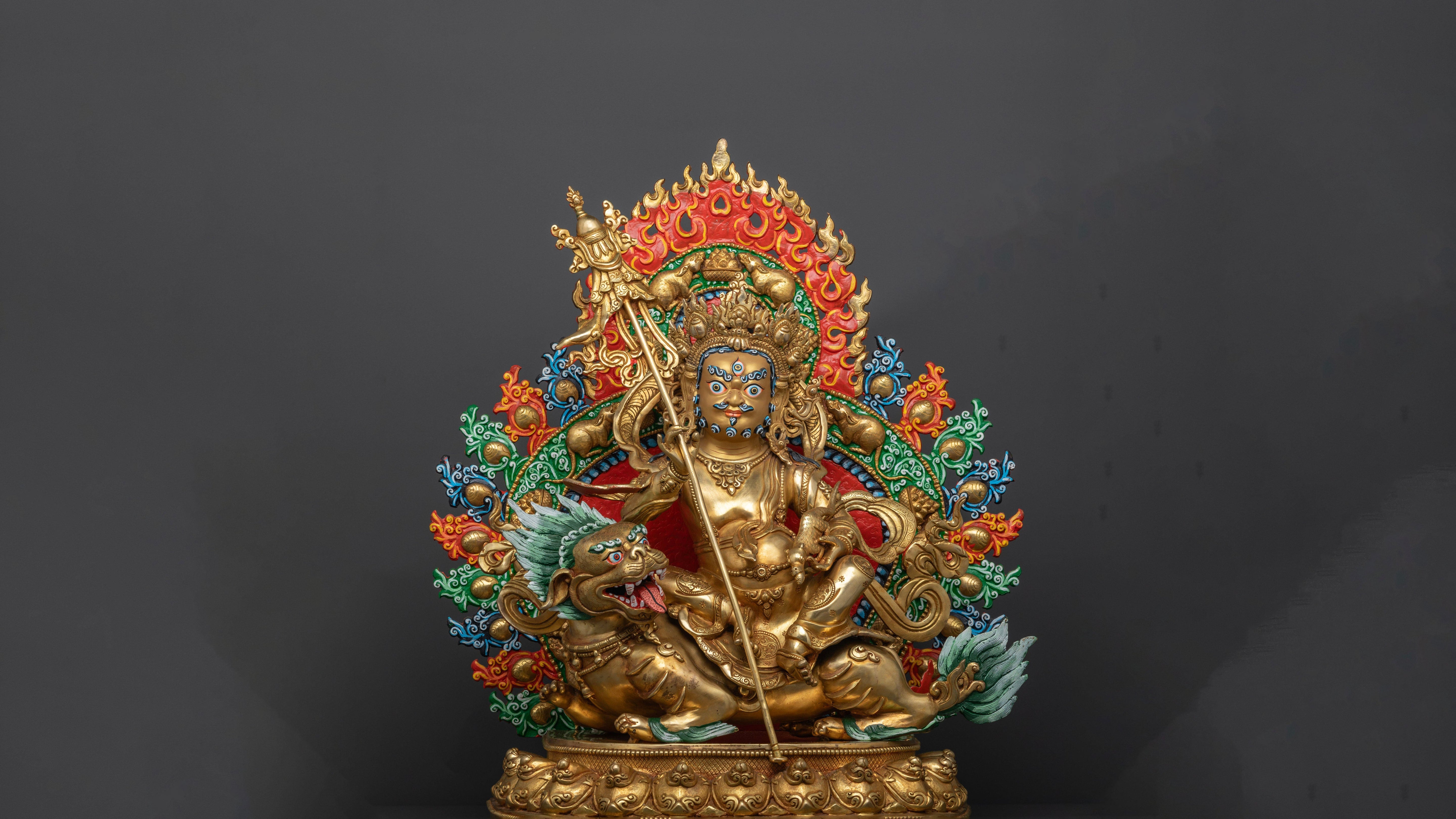 golden namtoshe statue with vibrantly colored accents in red, orange and blue