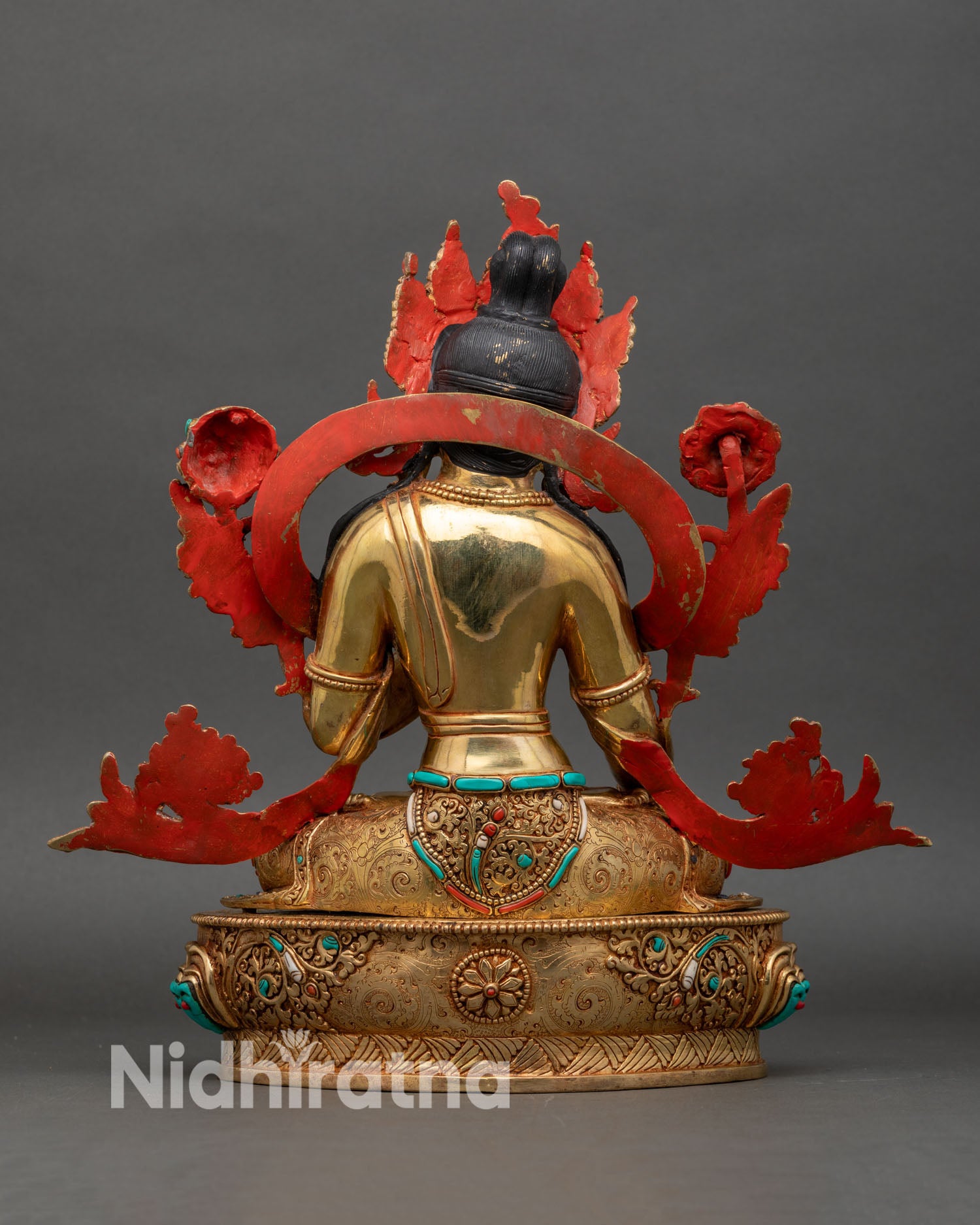 Back view of White Tara statue showing detailed lotus base and halo carving