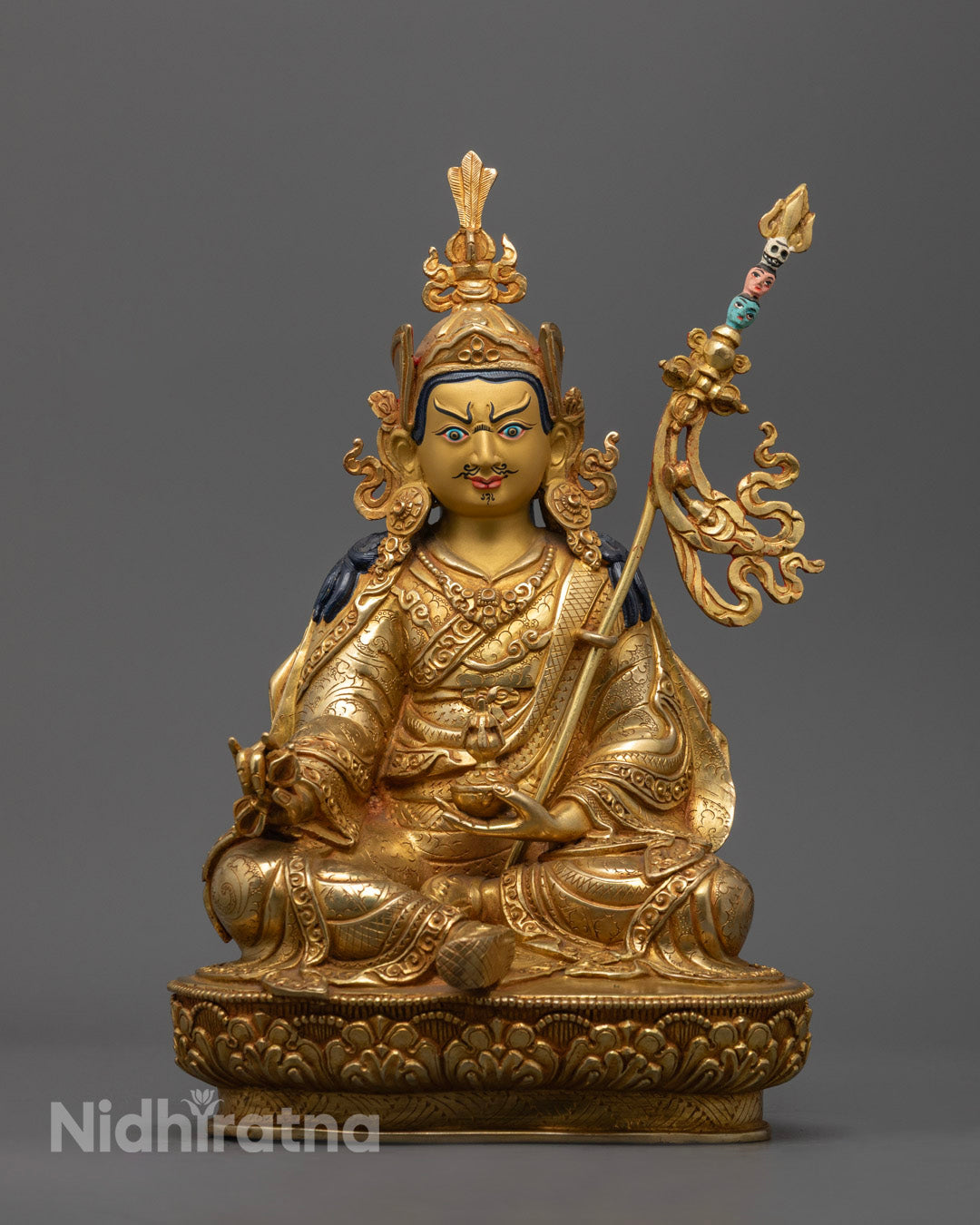 24K gold Guru Rinpoche statue seated on lotus throne with halo, holding vajra and skull cup, handcrafted in Nepal