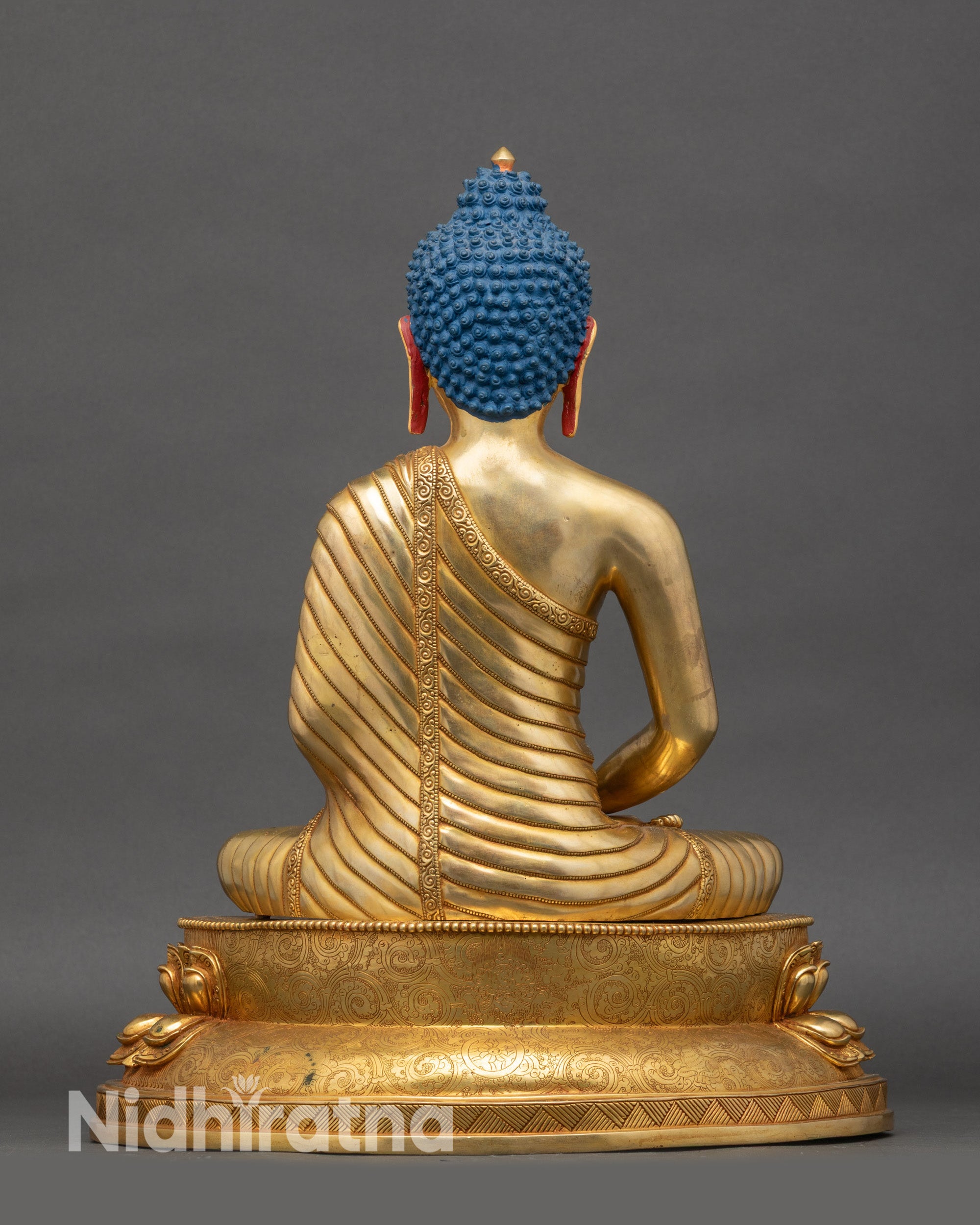 Back view of Amitabha Buddha statue, engraved lotus seat and flowing monastic garments