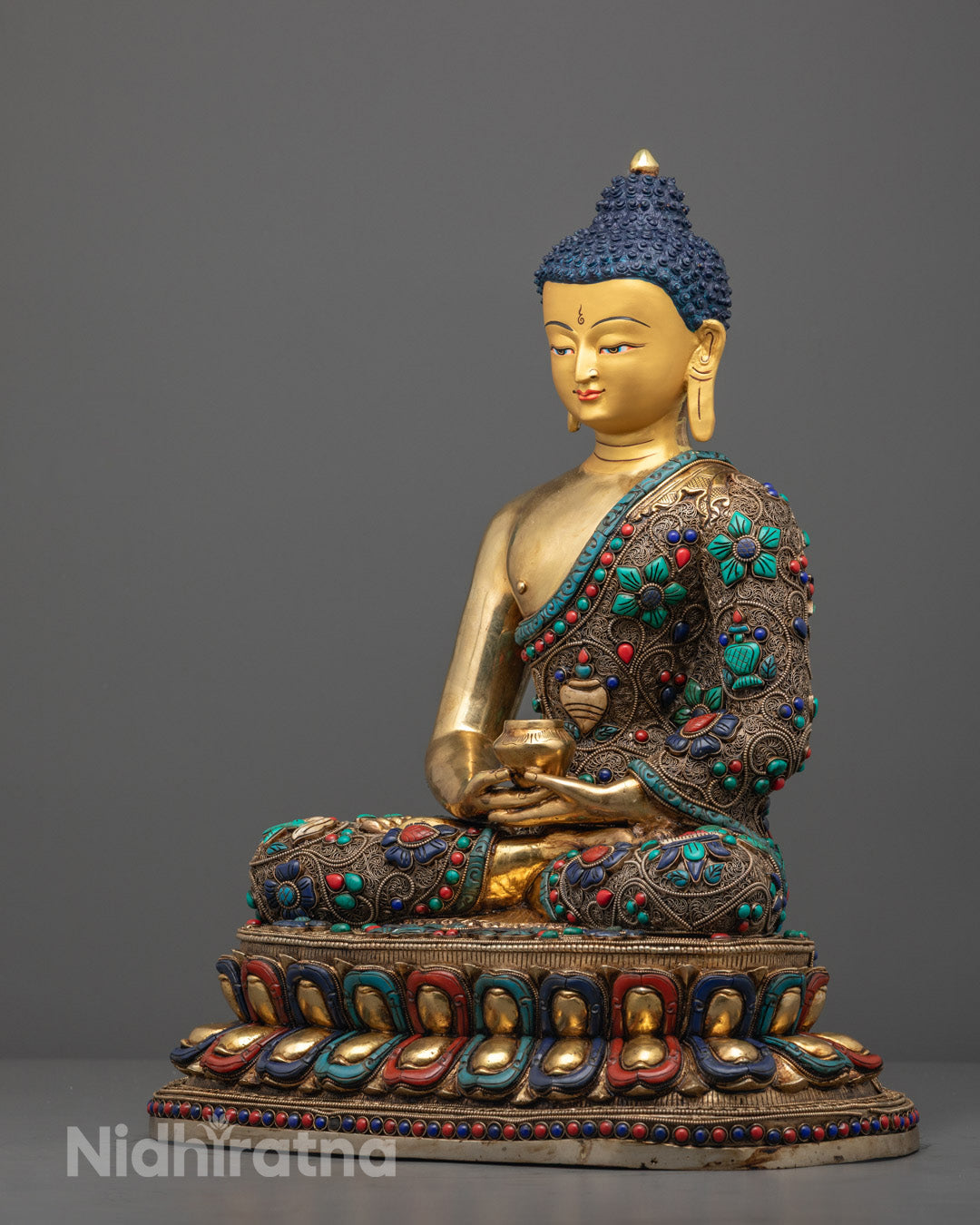 Amitabha Buddha statue seated on lotus throne decorated with semi-precious stones and vibrant acrylic colors