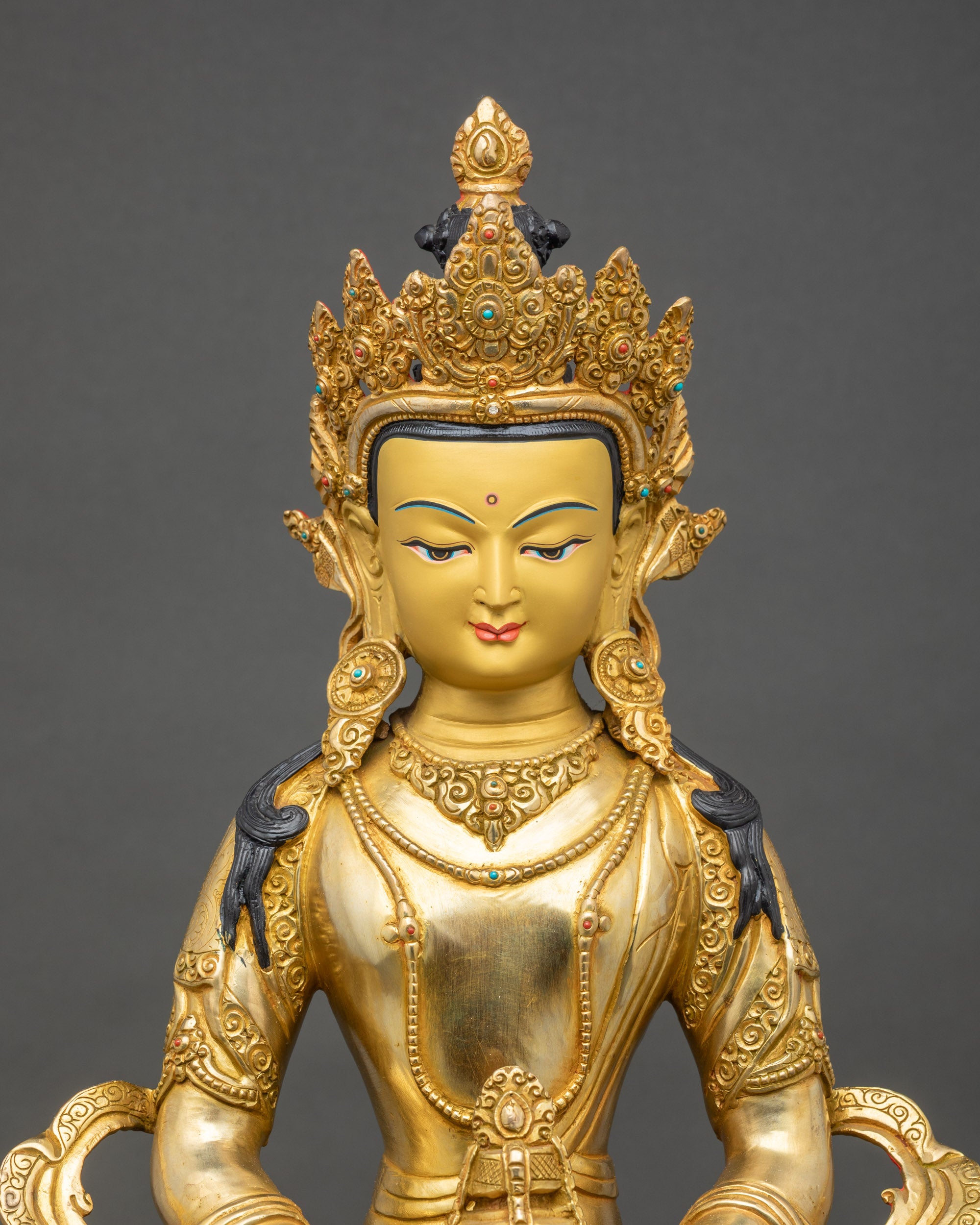 Regular close-up of Amitayus statue, polished gold layers and flowing Himalayan robes