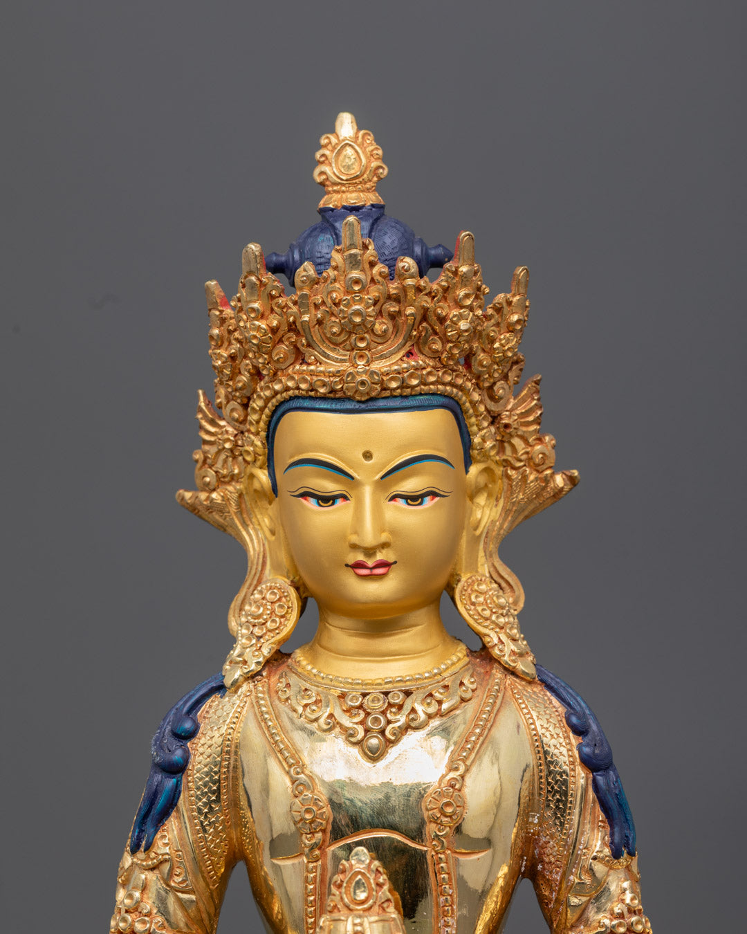 Amitayus statue seated on a lotus throne holding a long life vase filled with nectar representing vitality and wisdom