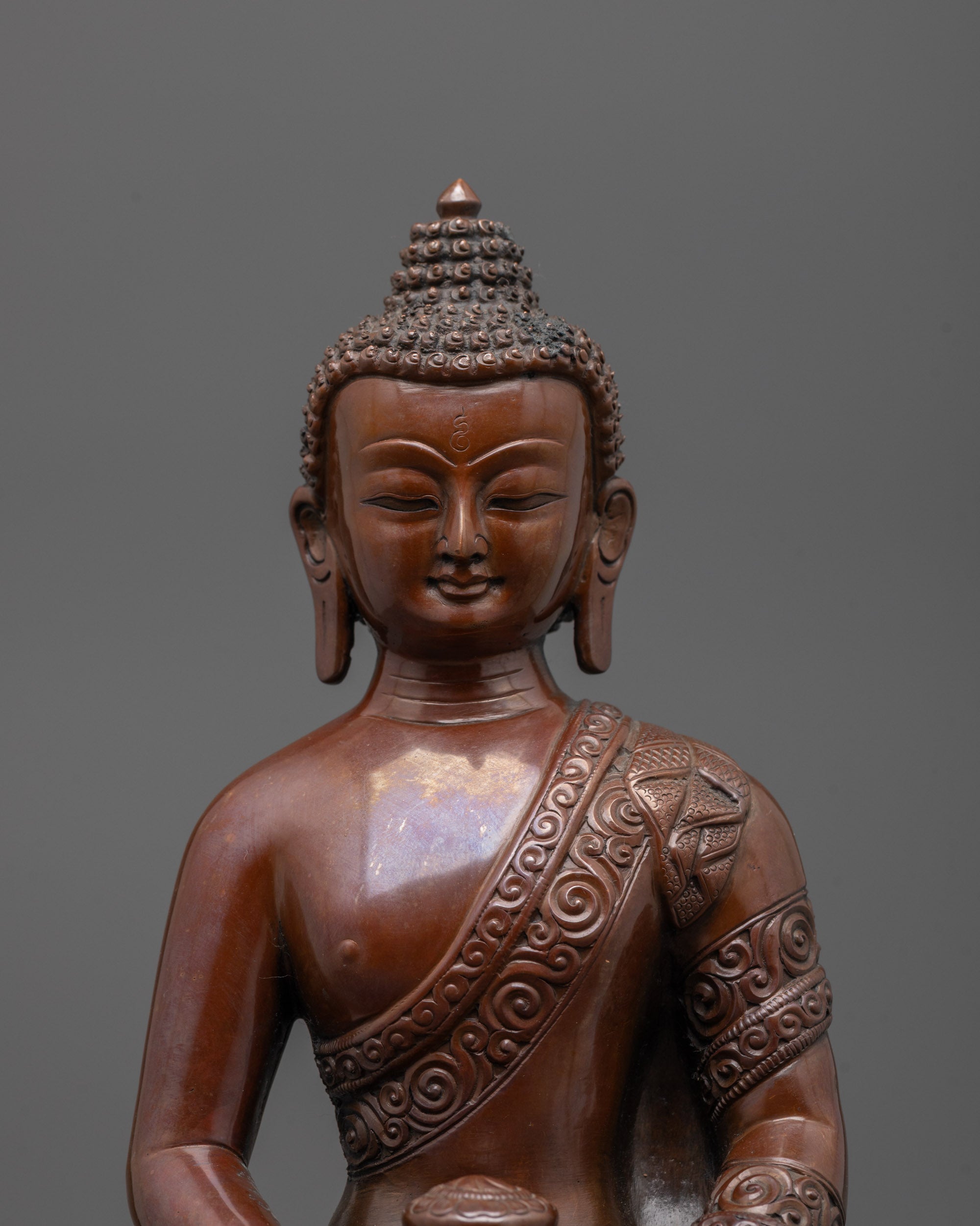 Close-up of Amitabha Buddha’s serene face with detailed oxidized finish