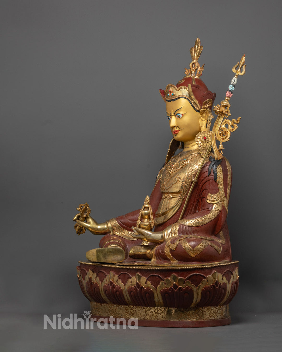 Artisan from Nepal skillfully crafting the Guru Rinpoche Statue using the traditional lost wax method in a workshop environment.