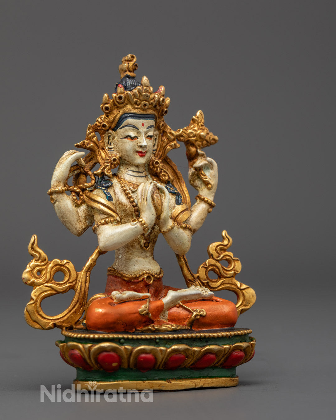 Avalokitesvara statue seated on a multi-coloured lotus throne with hollow base for mantra fillings, symbolizing meditation and spiritual focus.