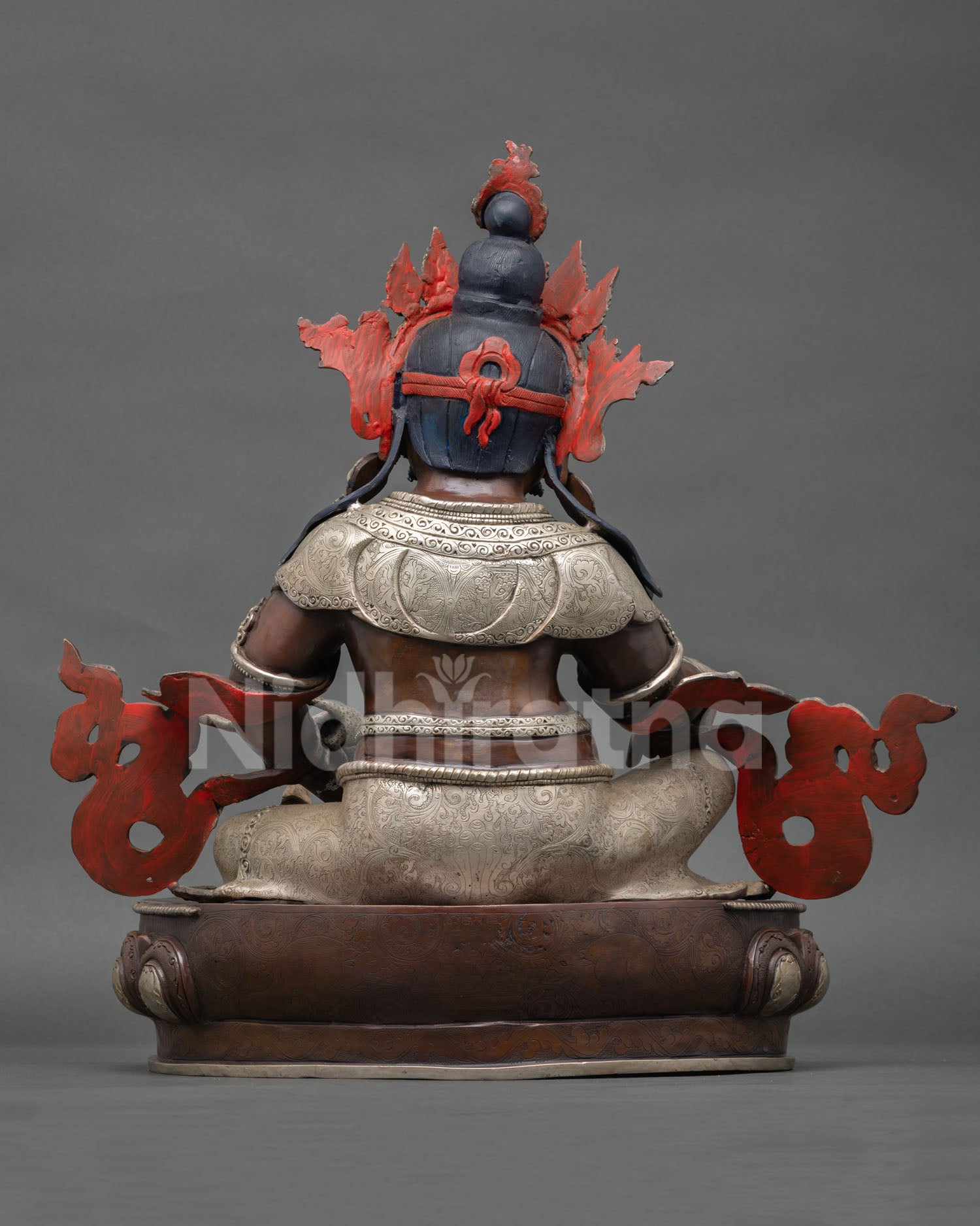 Back view of Dzambhala statue with ornate robe patterns and traditional Nepalese craftsmanship