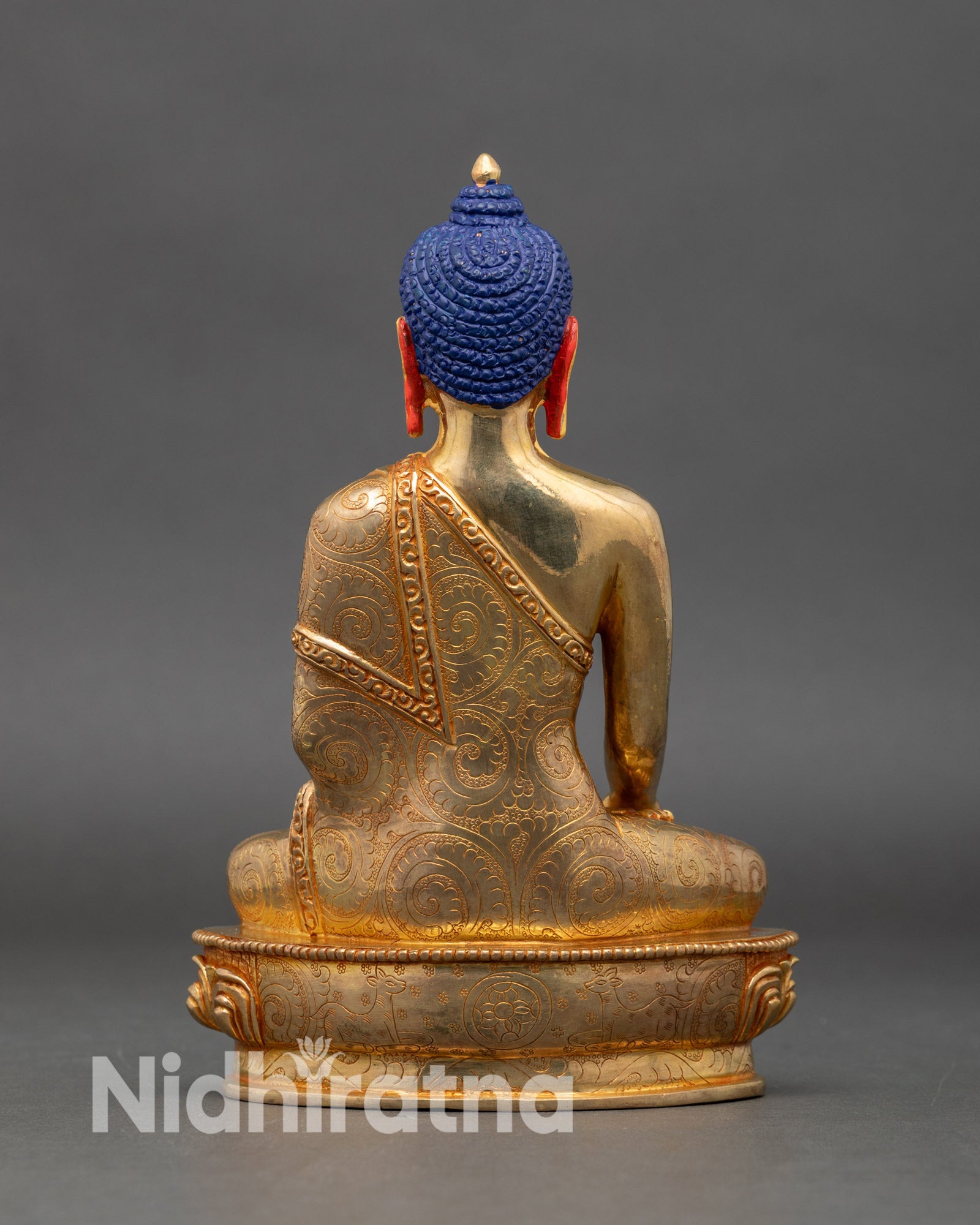 Back view Shakyamuni Buddha statue, intricate gold accented robes and lotus pedestal