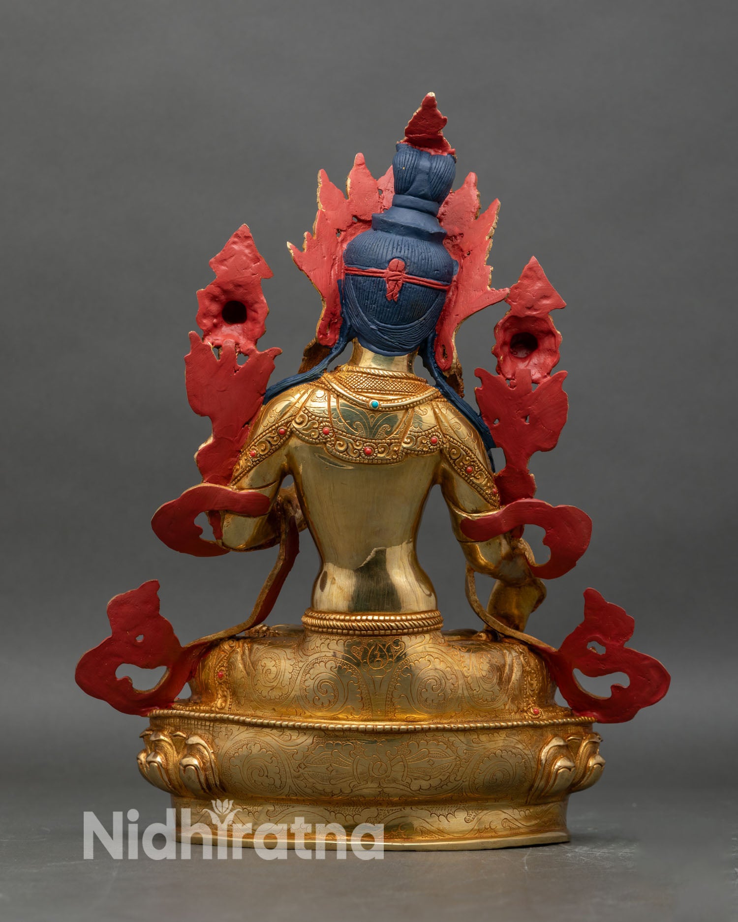 Back view of White Tara statue showing engraved details and lotus pedestal