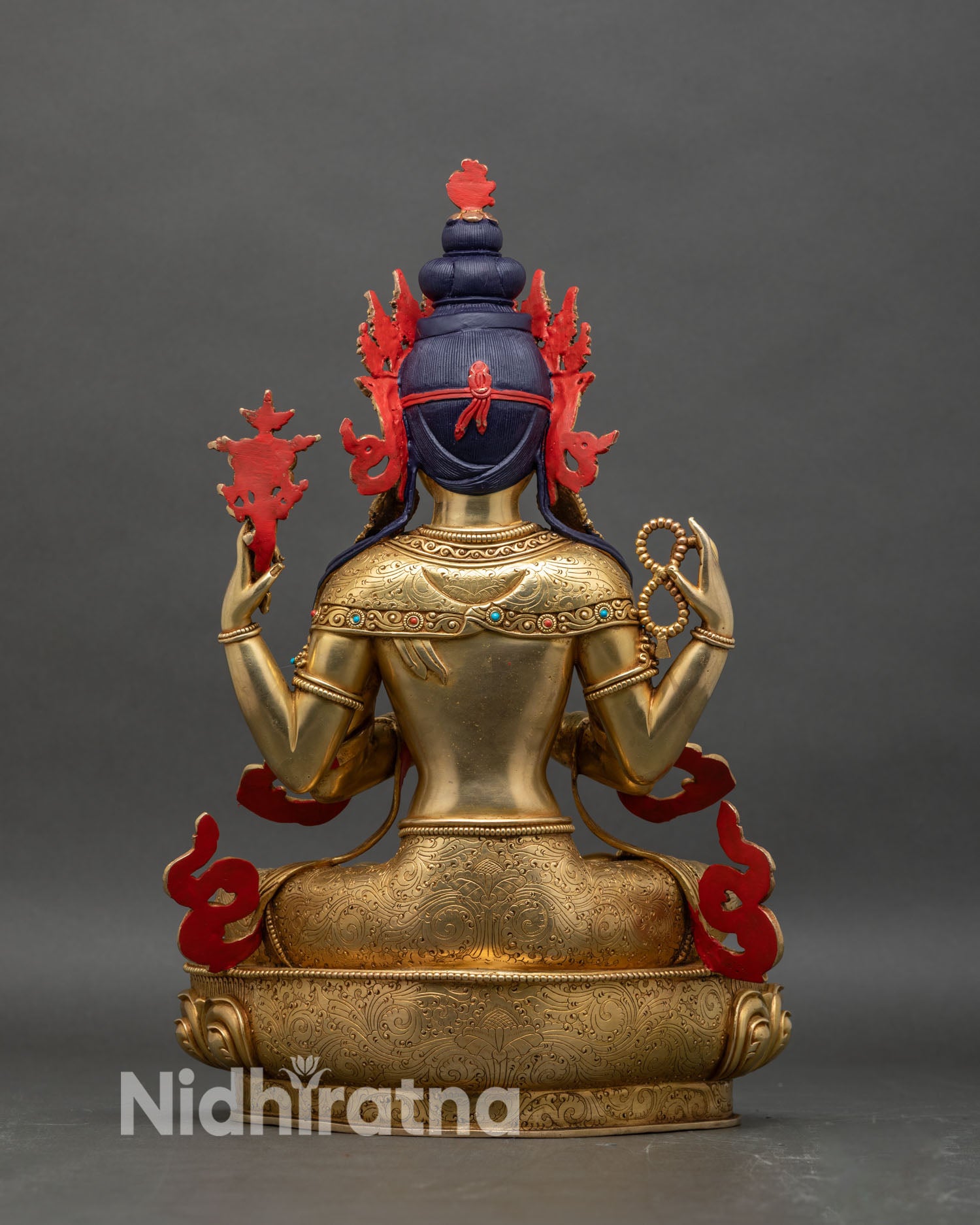 Back view of Chenrezig statue showing engraved lotus pedestal and hollow chamber for mantras