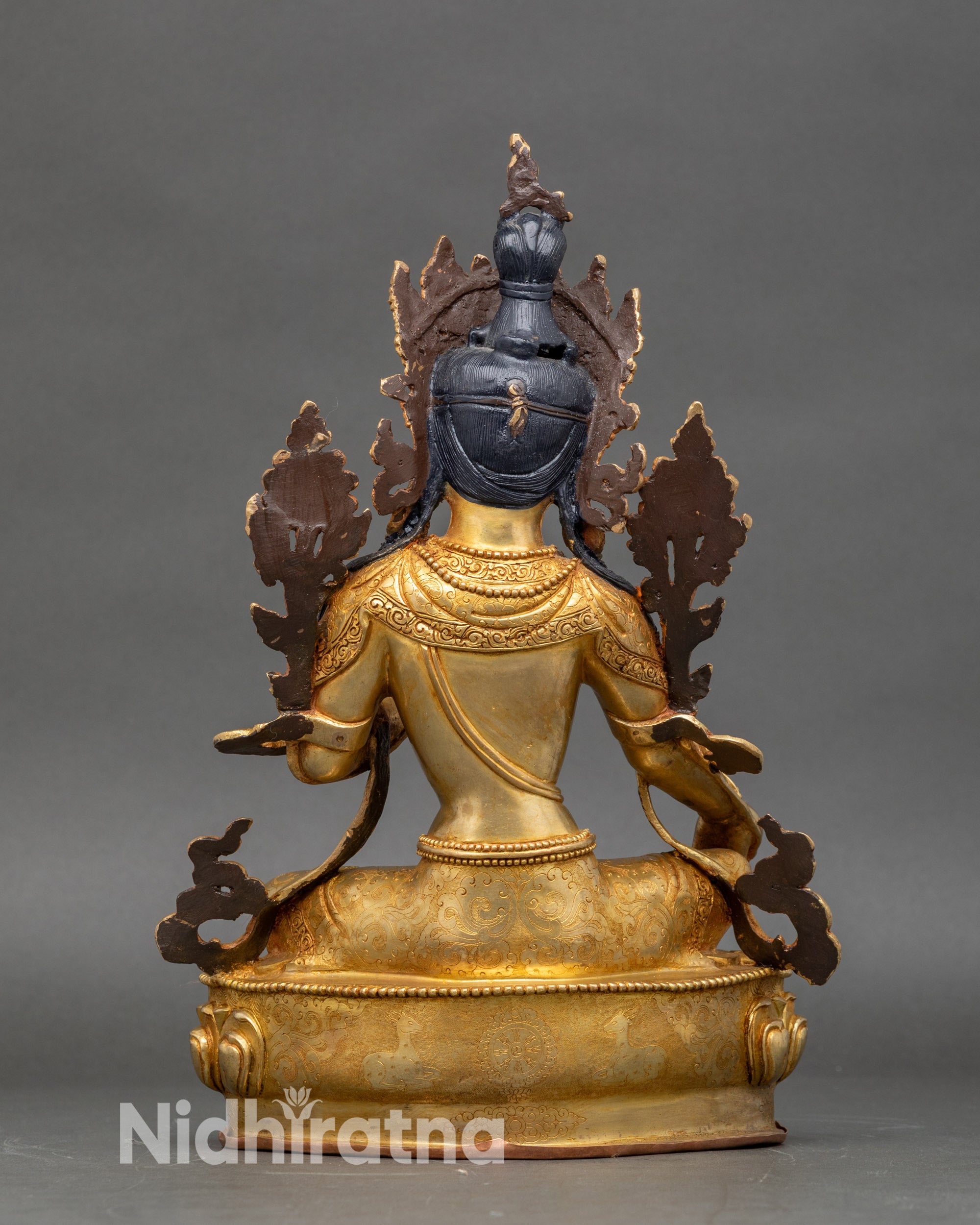 Back view of Green Tara statue, engraved lotus pedestal and decorative robes in gold finish