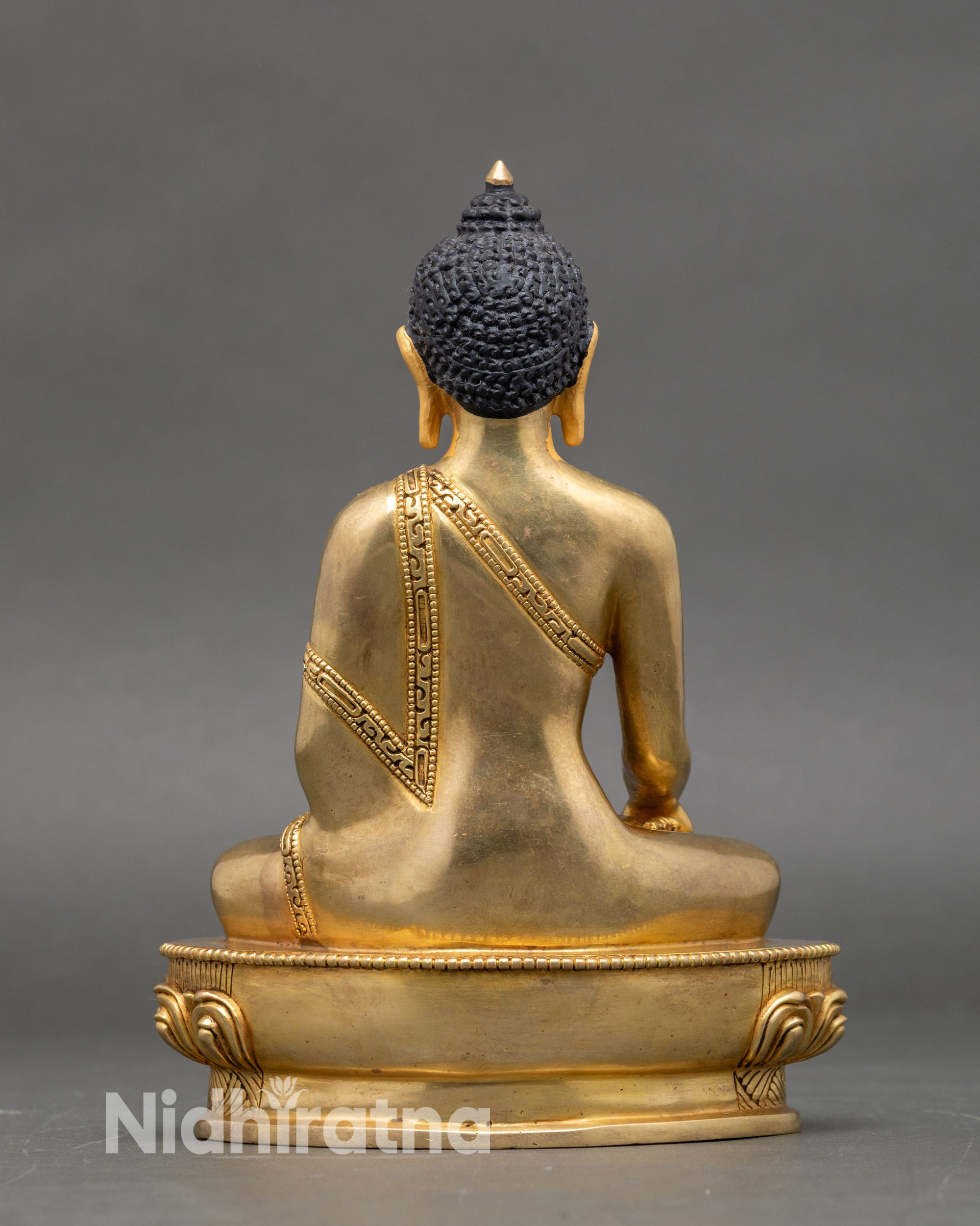 Back view of Shakyamuni Buddha statue, detailed lotus pedestal and embossed robe design