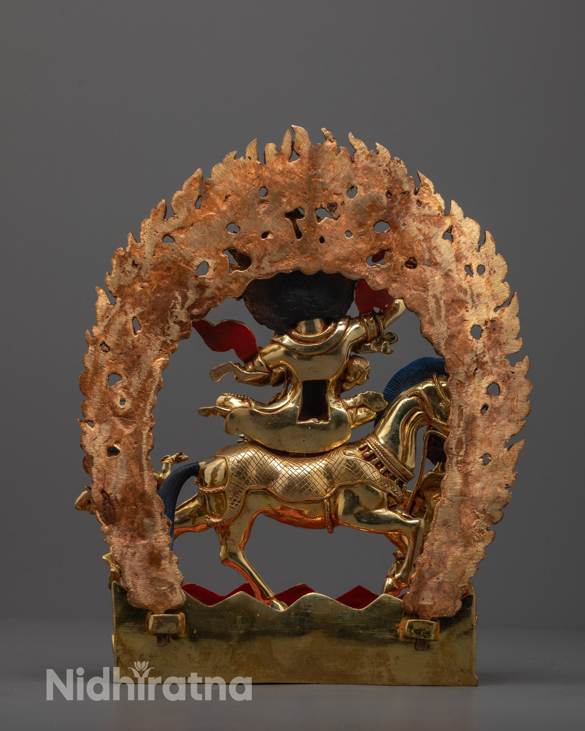 Back-view of Palden Lhamo Statue seated on a horse with fierce aura and gold accents