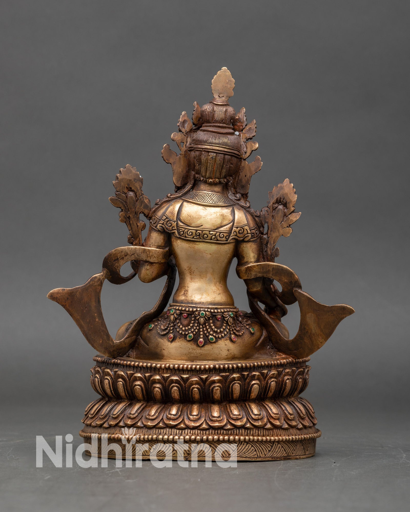 Back view of White Tara statue showing lotus pedestal and detailed oxidized finish