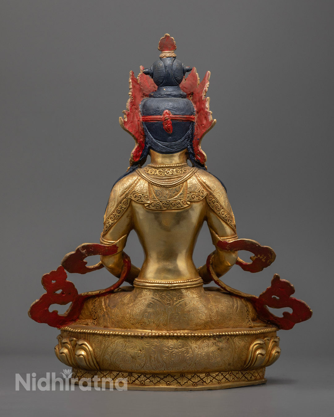 Highlights the consecrated hollow chamber for mantras or relics and the rich symbolism of the statue’s flowing robes and base design.