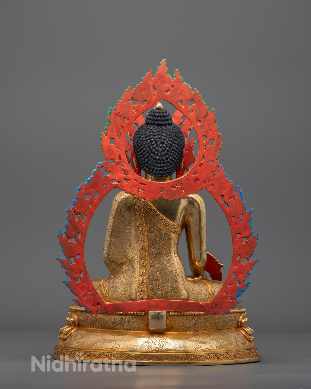 Back angle highlighting gold fire-gilded body and detailed monk’s robe on Tibetan Buddha statue