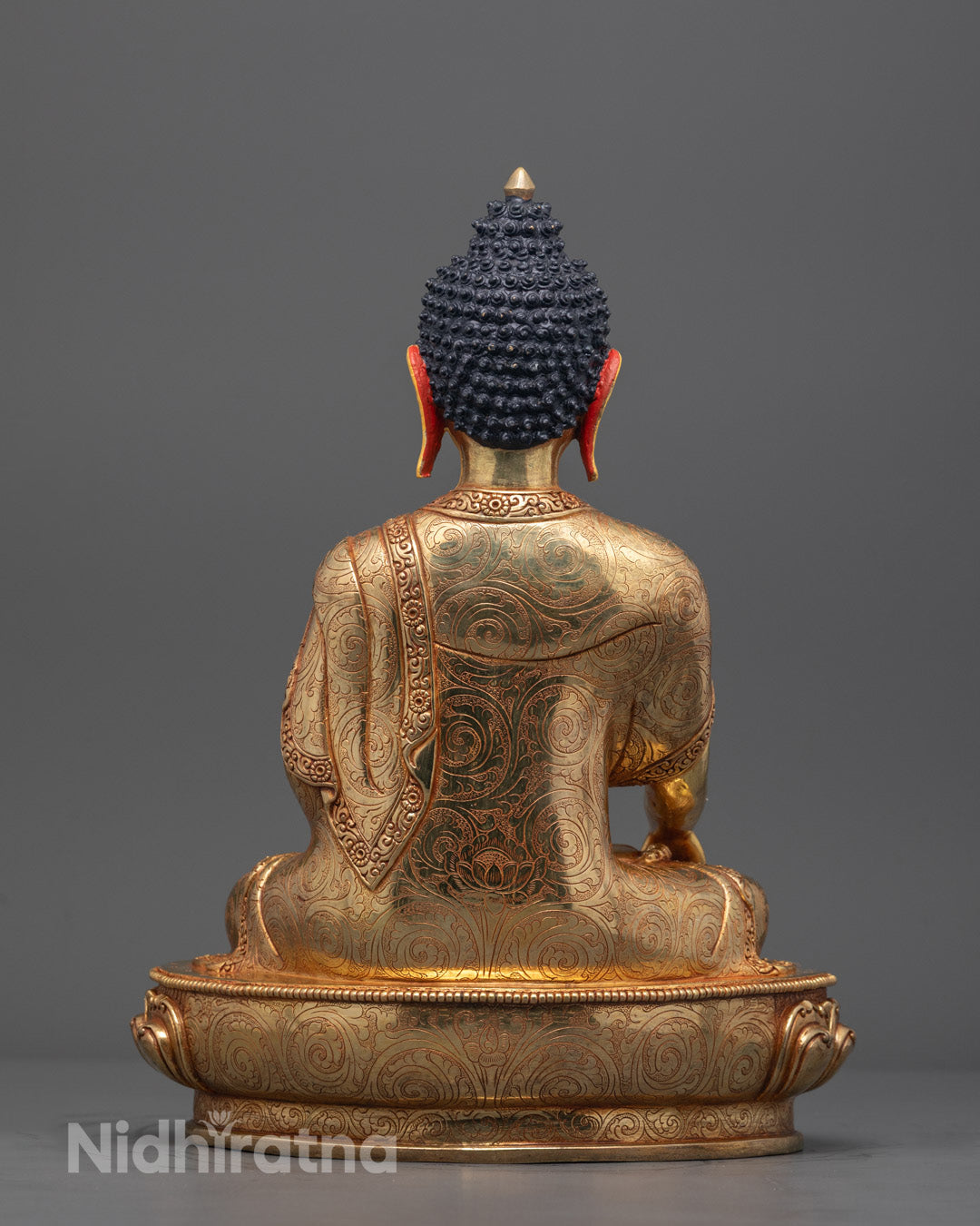 Back angle of Shakyamuni statue with intricate lotus base and monk robe detailing