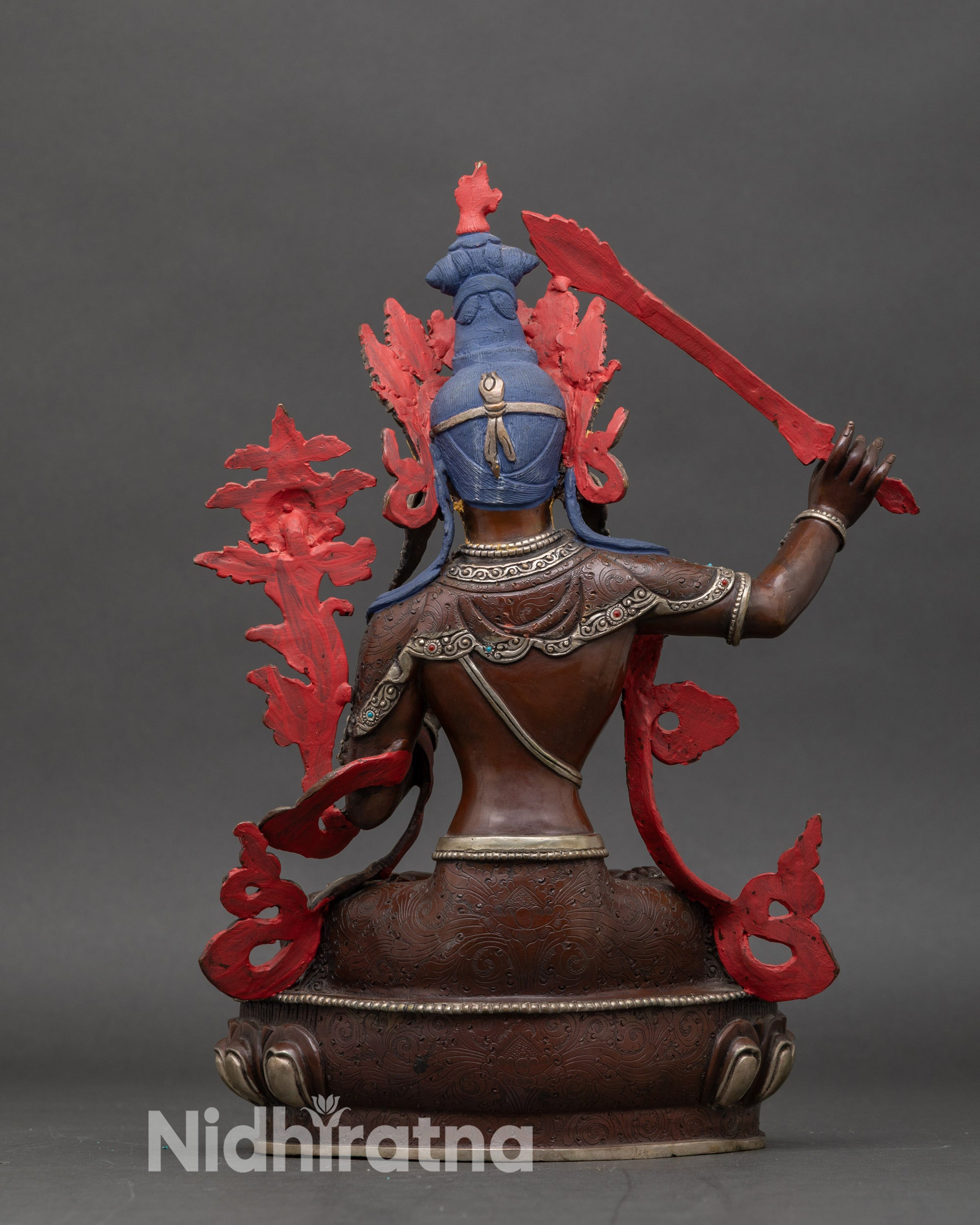 Back of Manjushri statue showing lotus pedestal and copper oxidized detailing