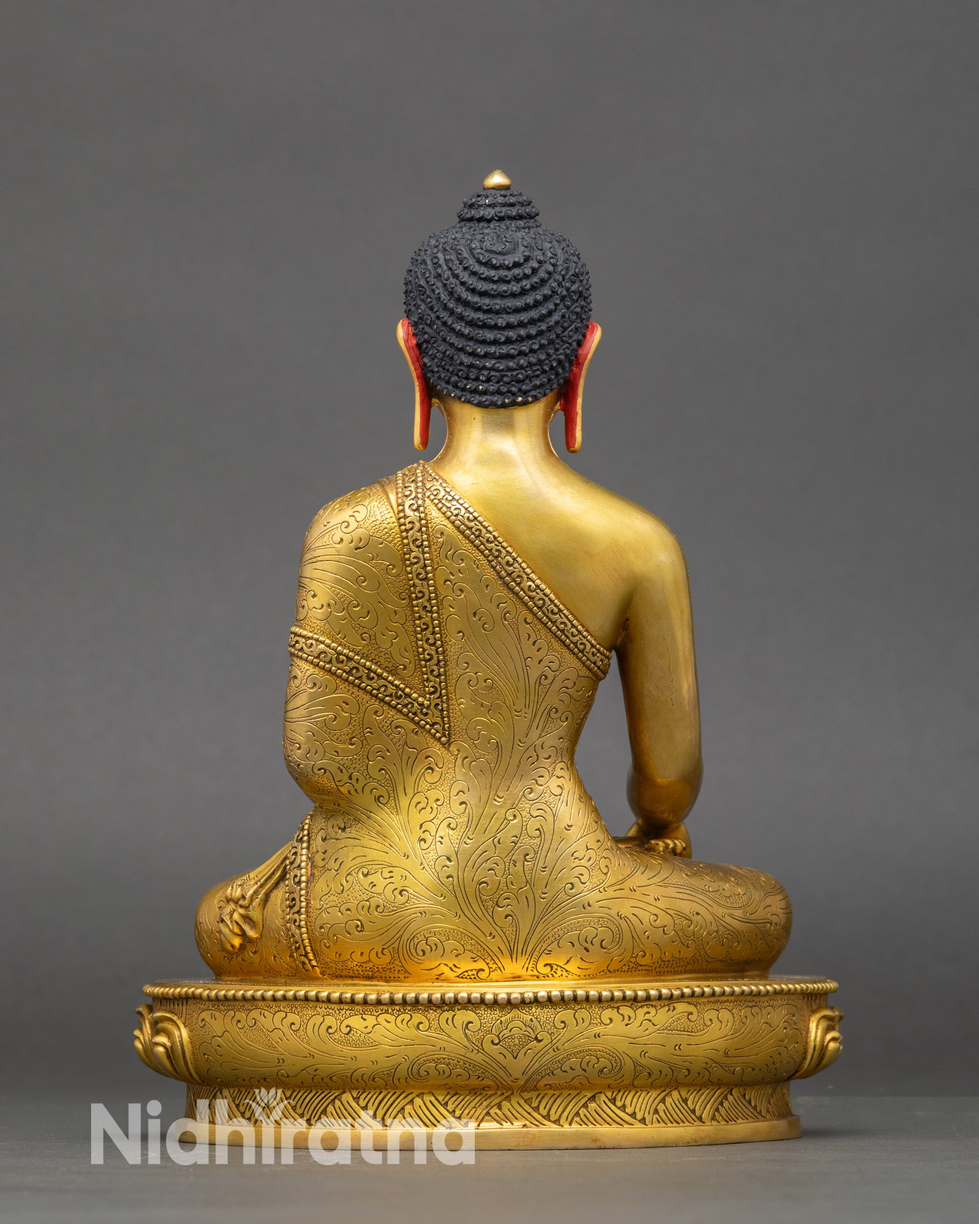 Back of the Shakyamuni Buddha statue showing detailed lotus pedestal, engraved patterns, and copper craftsmanship.