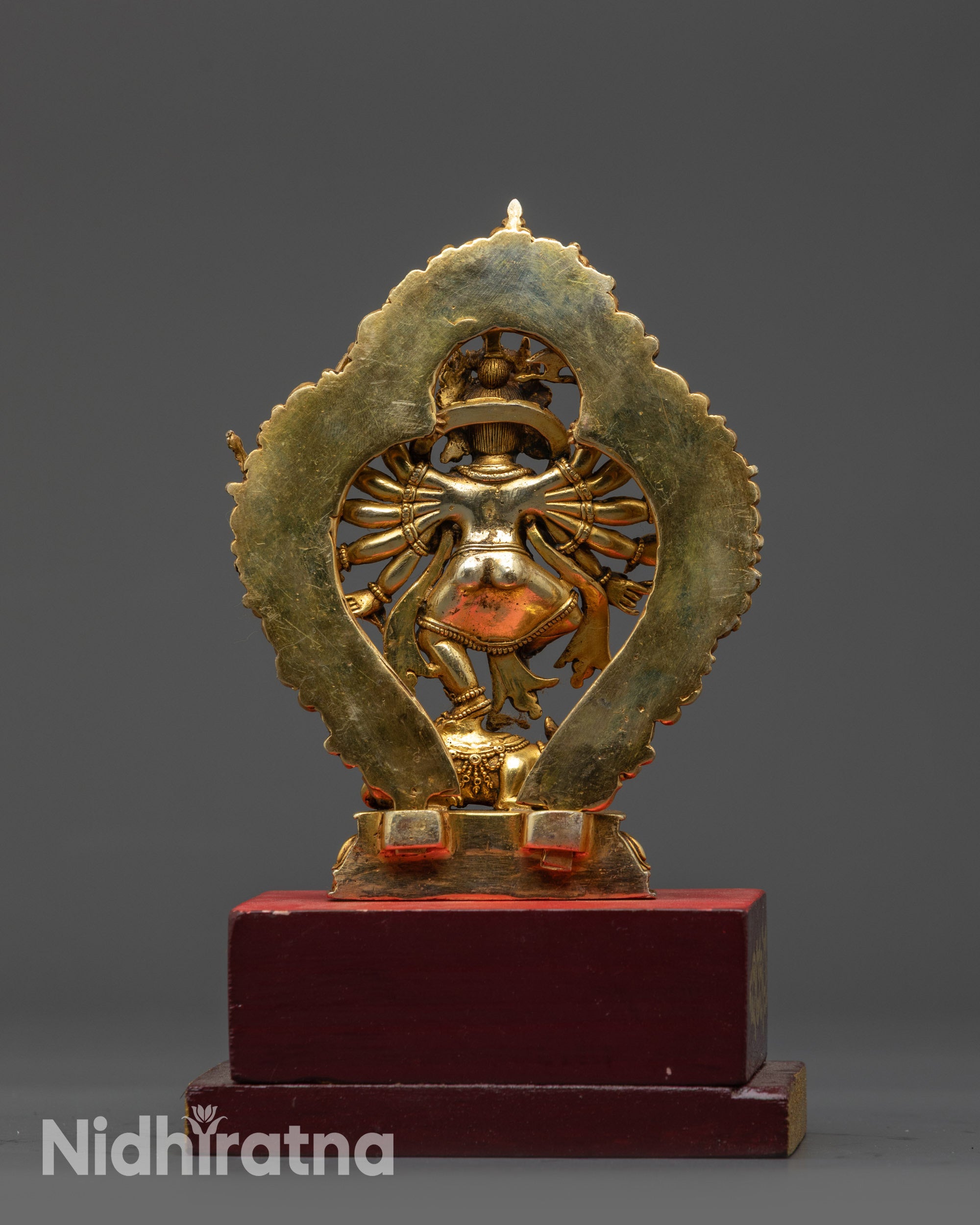Back view Ganesh statue showing lotus seat, robes, and wooden base