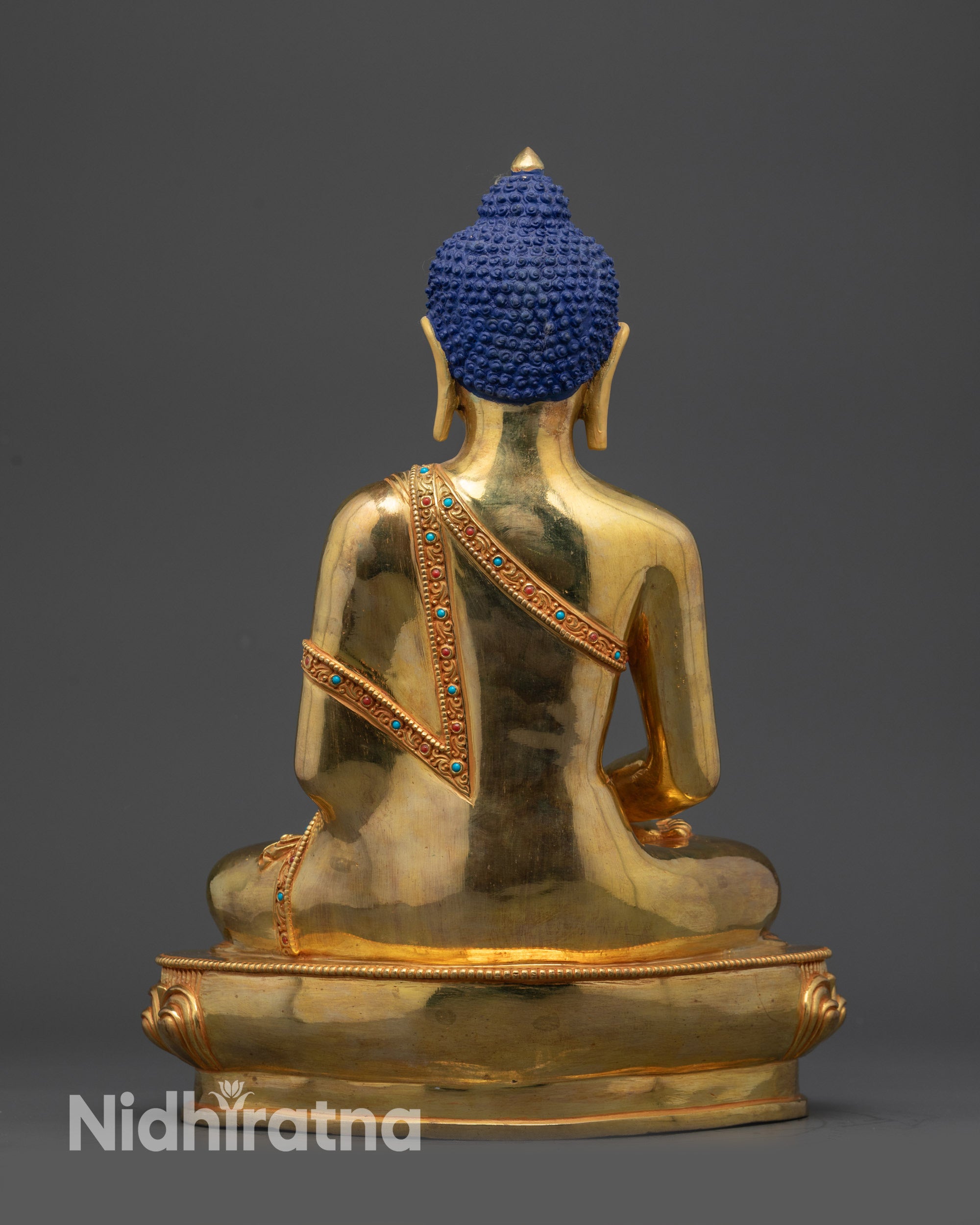Back view of Amitabha Buddha sculpture with intricate robe carvings and polished copper base
