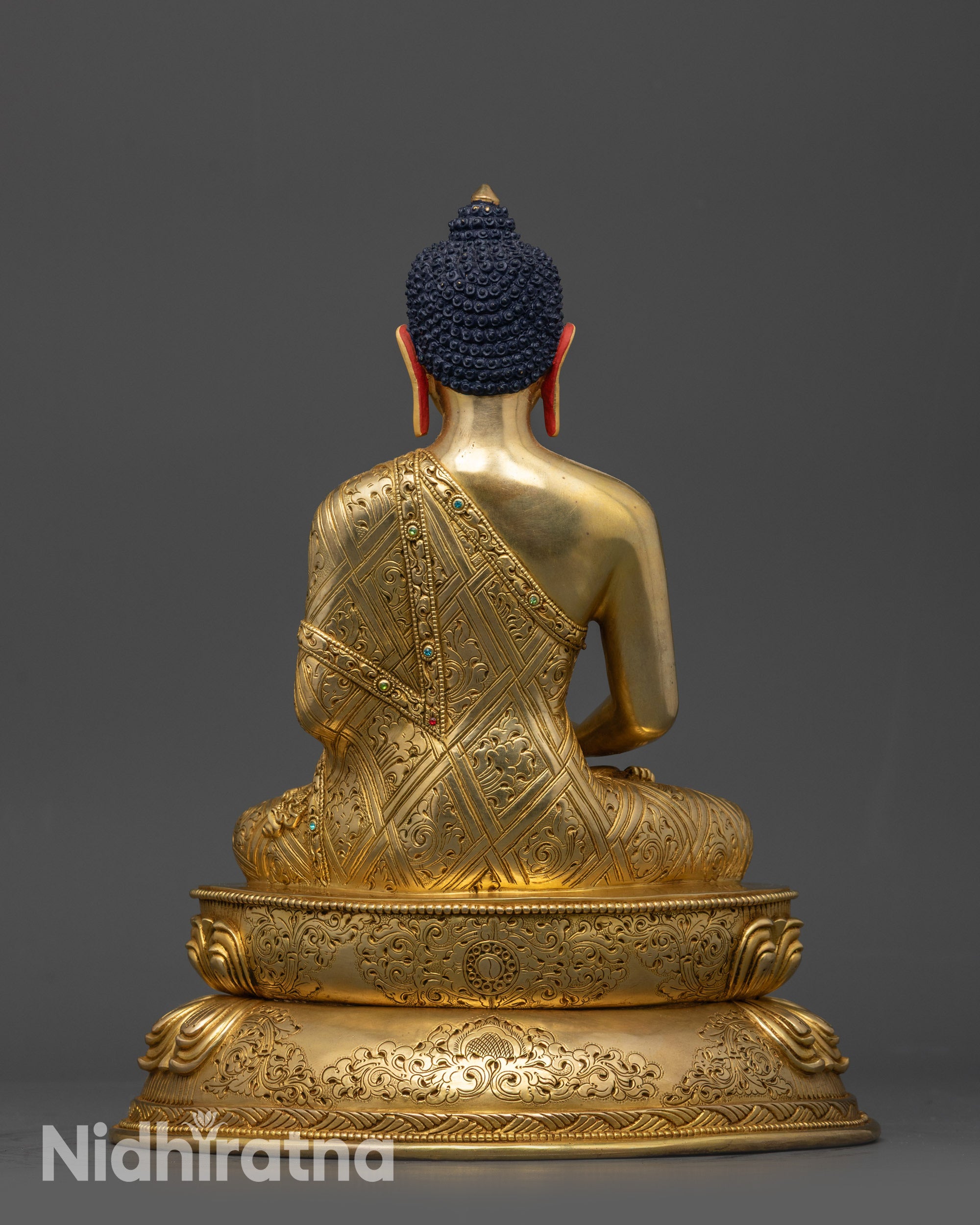 Back view of Amitabha Buddha statue showing intricate carved patterns on robe and base