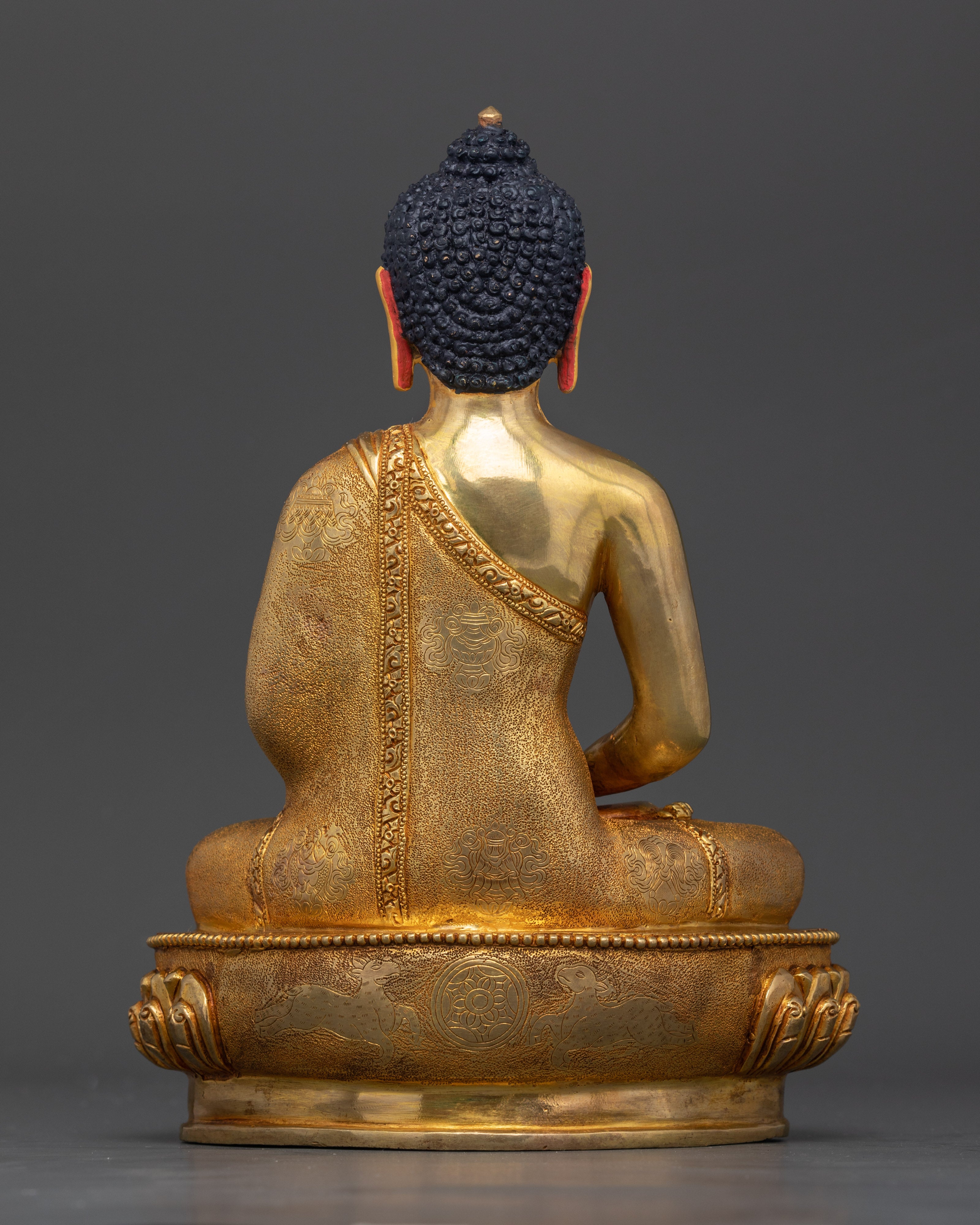 Back view of Amitabha Buddha statue showing intricate fire-gilded details, meditation altar