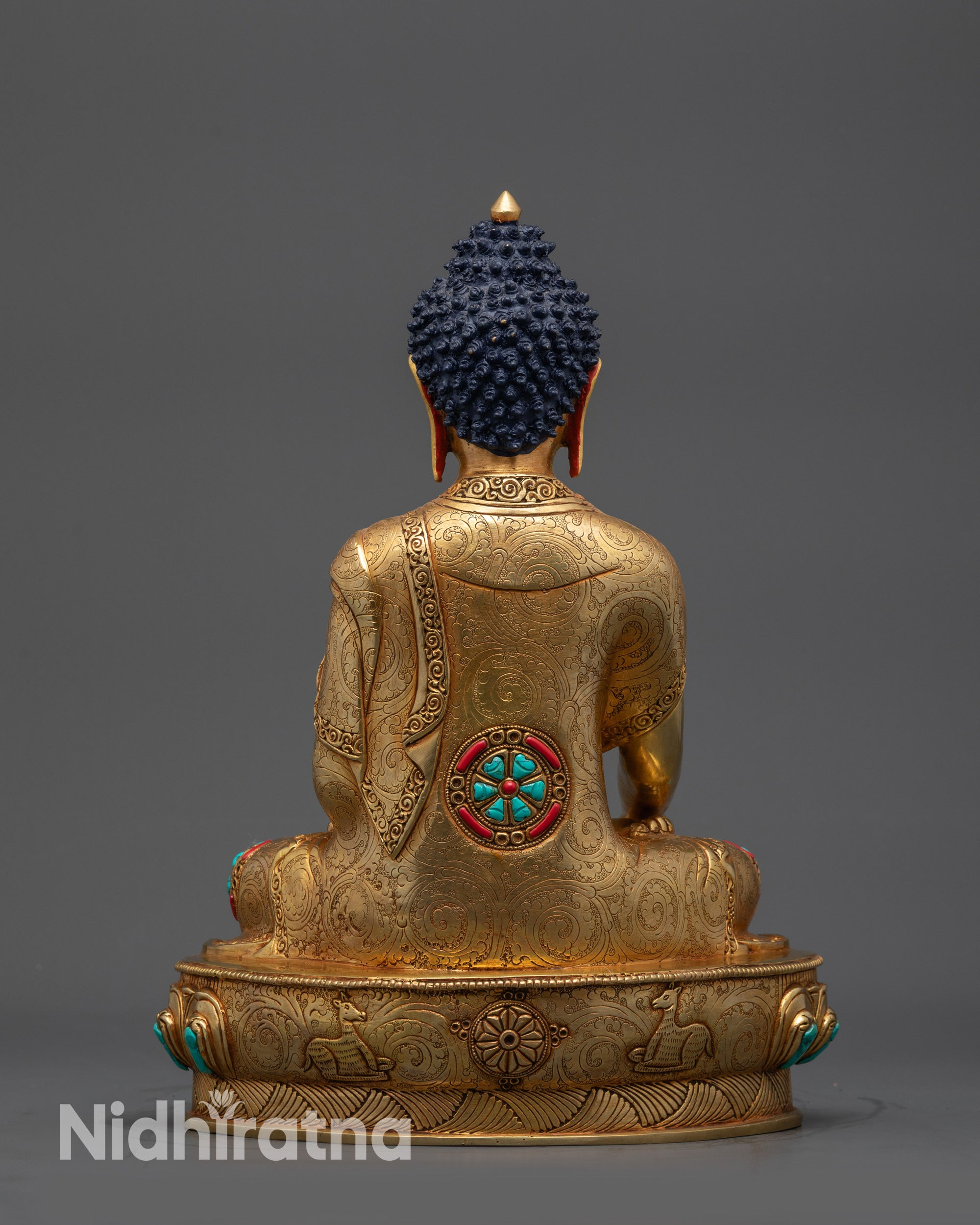 Back view of Buddha Shakyamuni statue displaying gold-gilded base and lotus throne