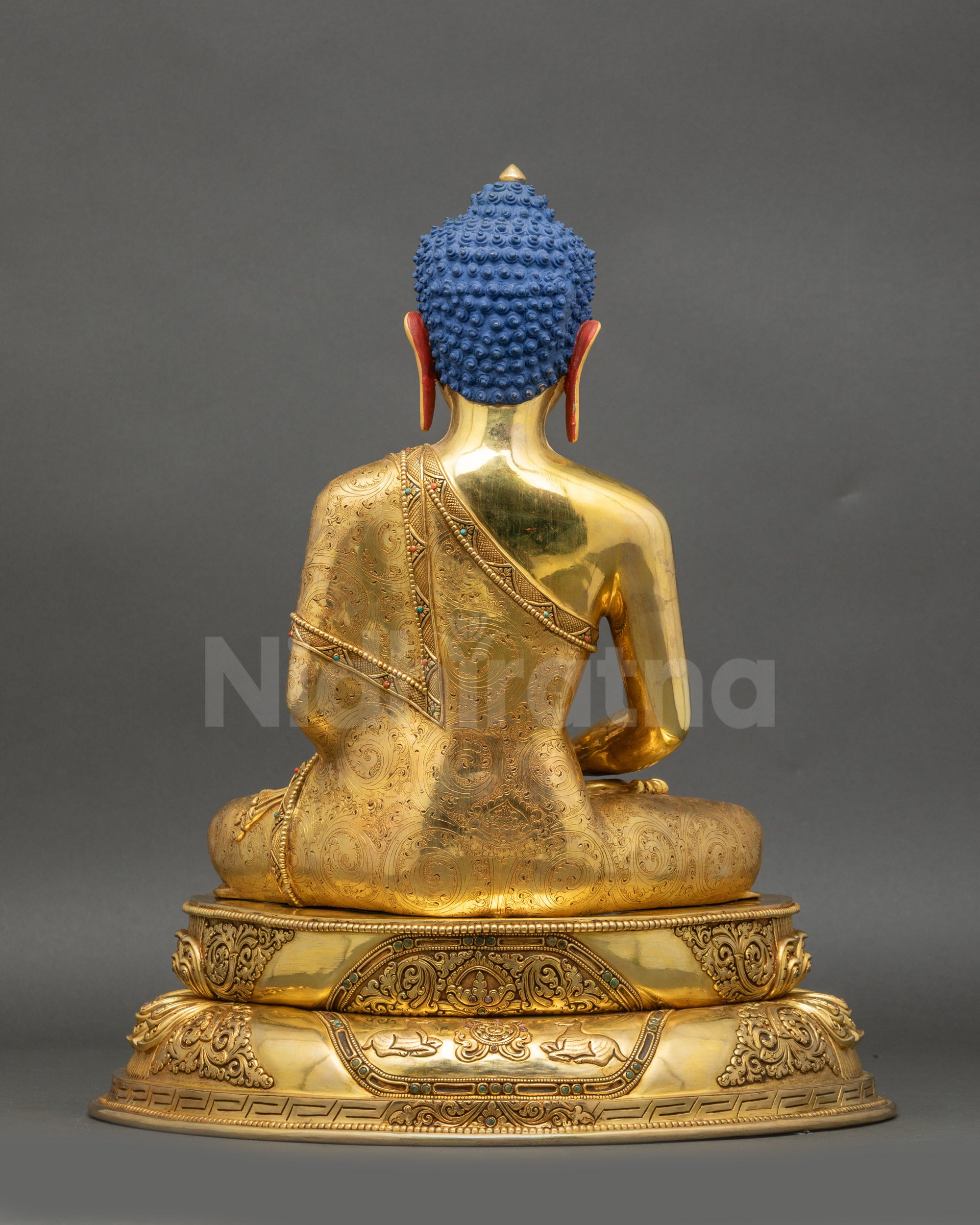 Back view of Buddha statue featuring Wisdom Wheel and pair of Deer on pedestal