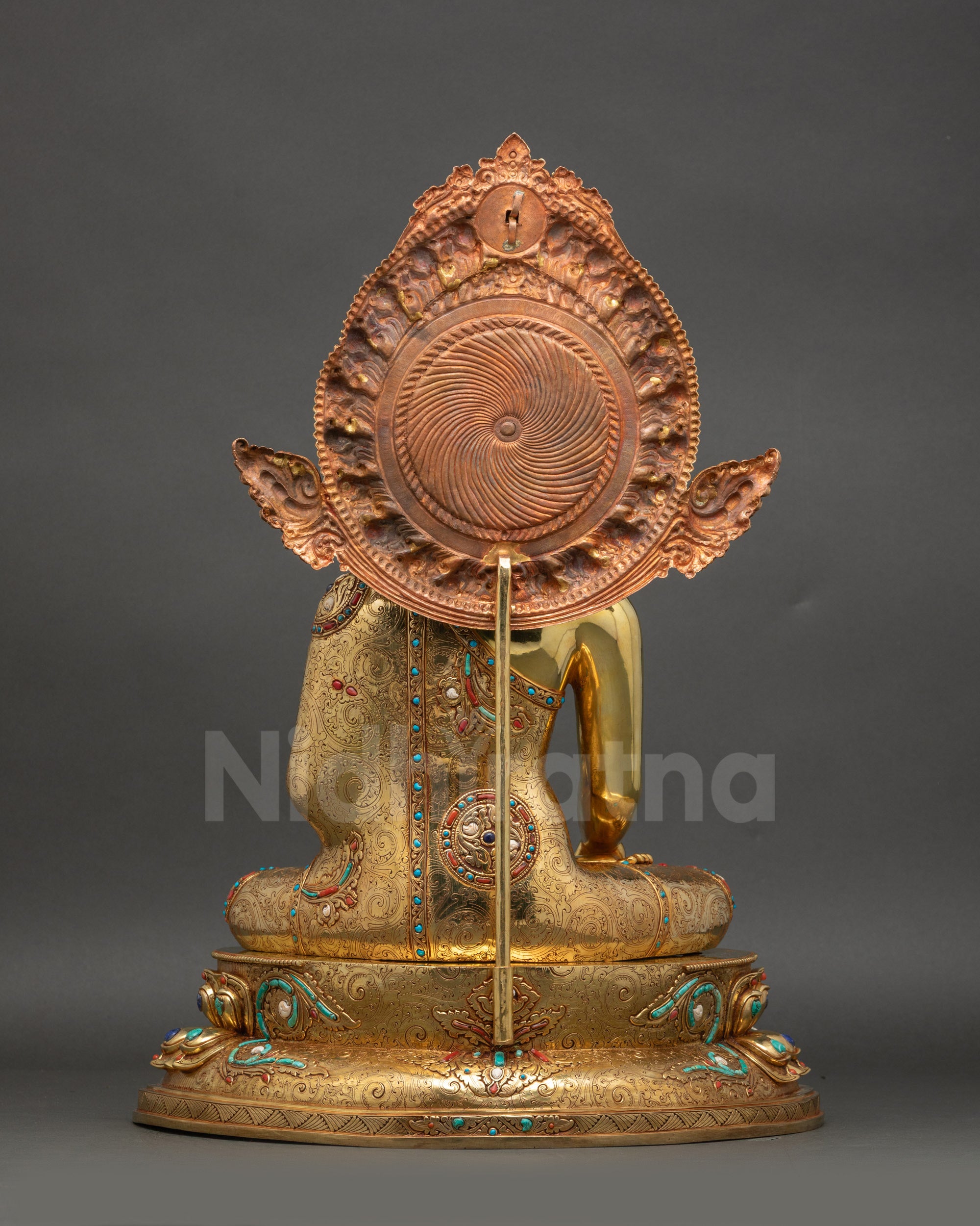 Back view of Buddha statue featuring intricately carved floral halo and lotus pedestal