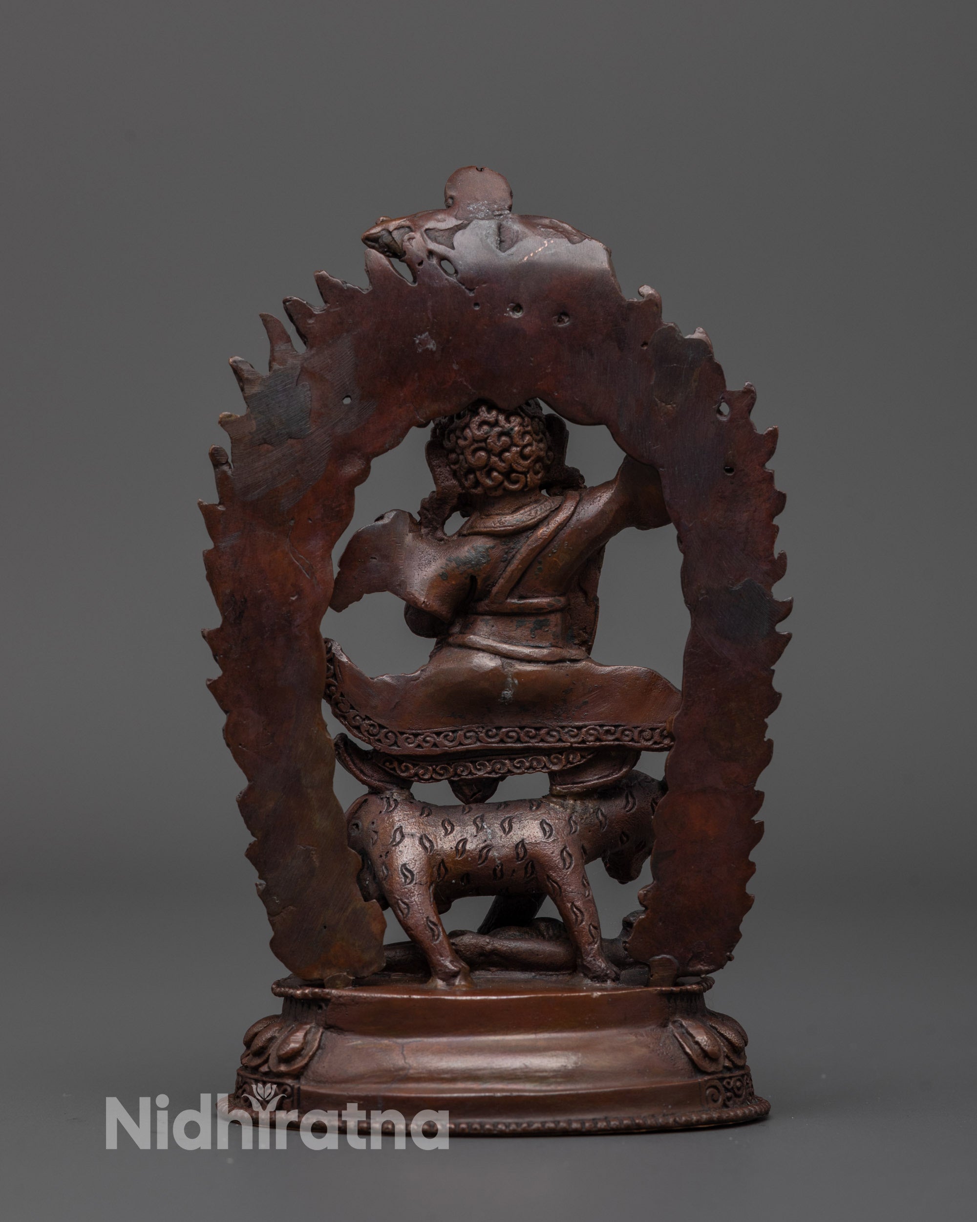 Back view of Dorje Drolo Statue highlighting detailed carvings and oxidized copper surface
