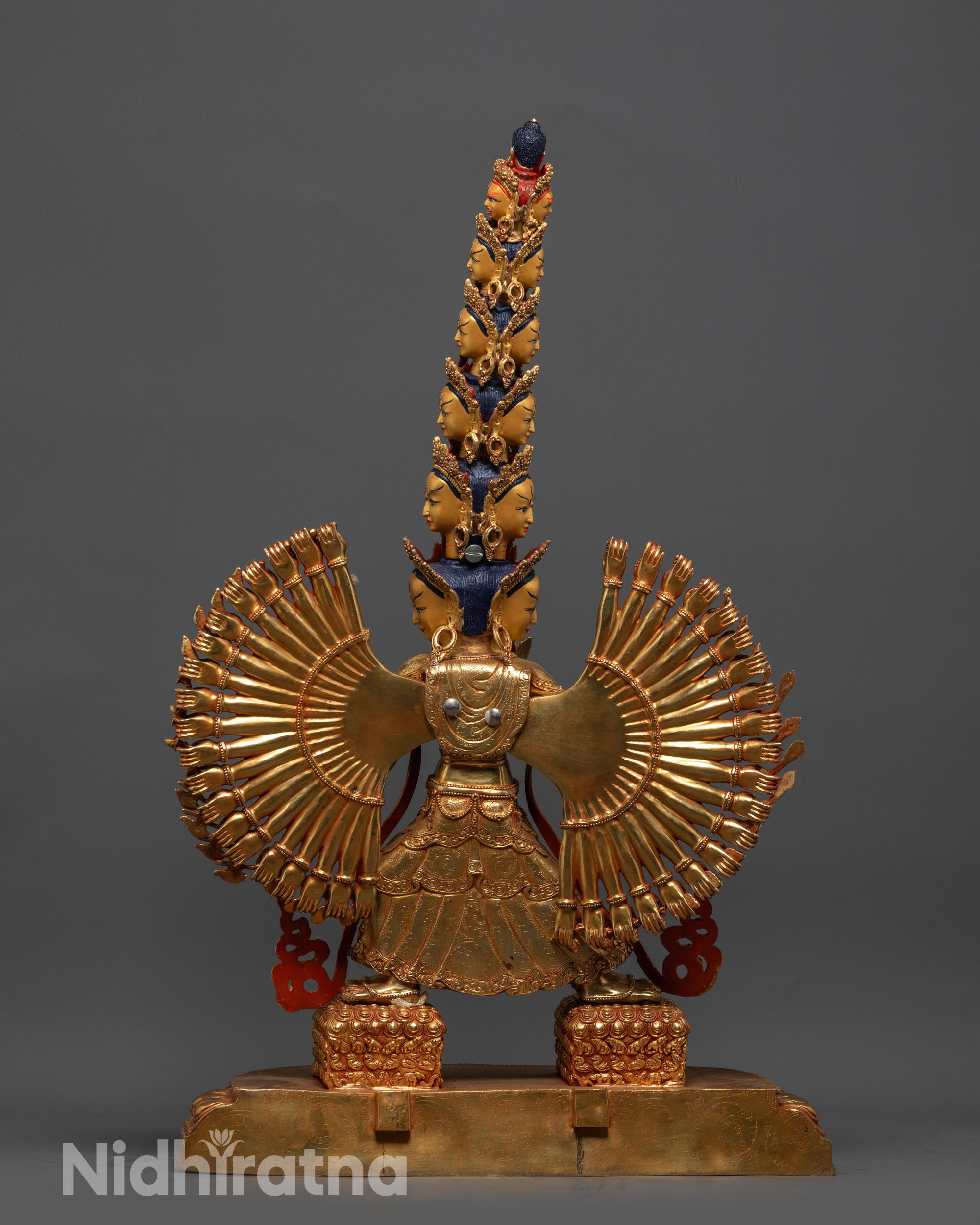 Back view of Dukar Statue displaying gold-gilded body and symmetrical arm arrangement