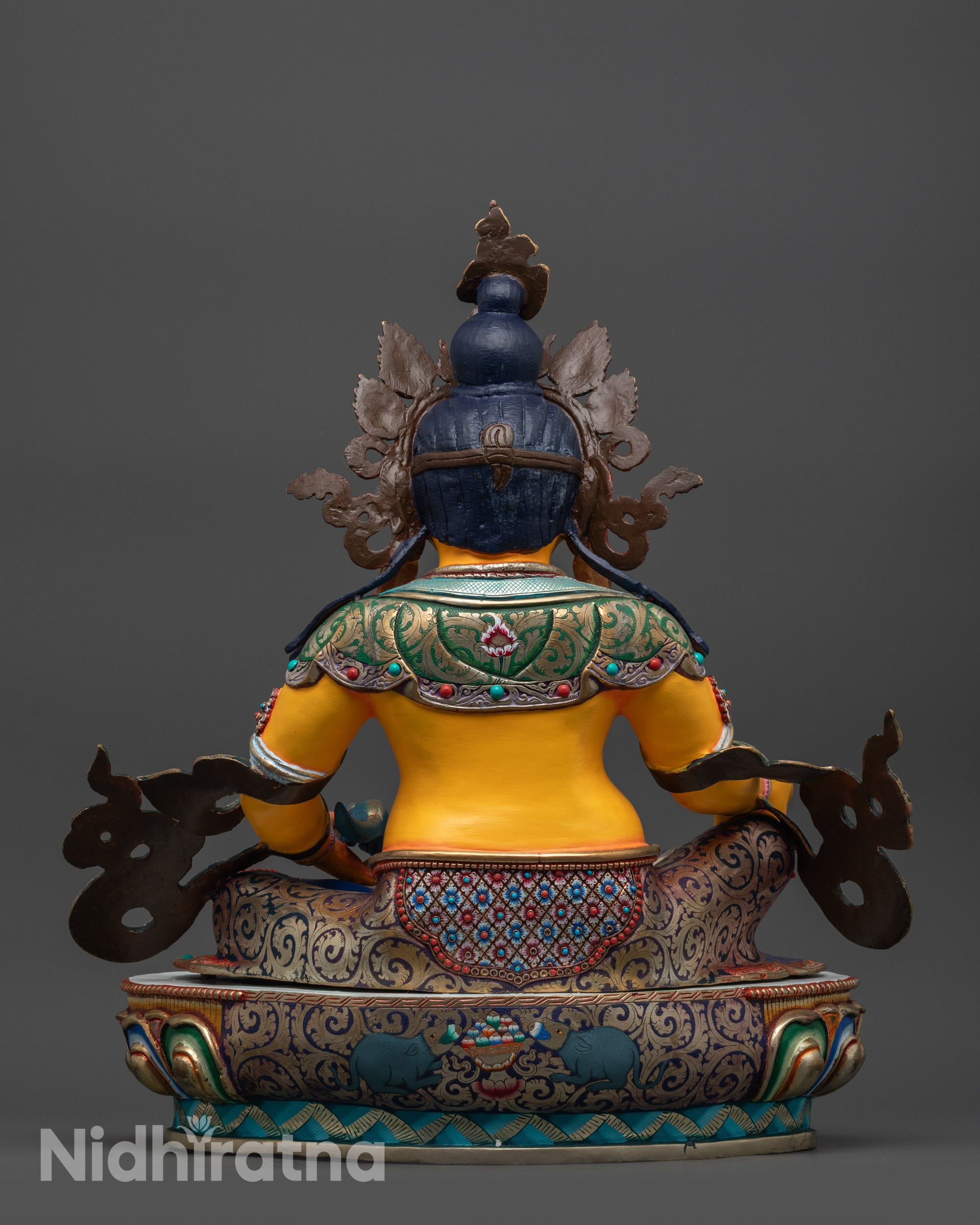 Back view of Dzambhala sculpture highlighting coloured lower garments and shell crown