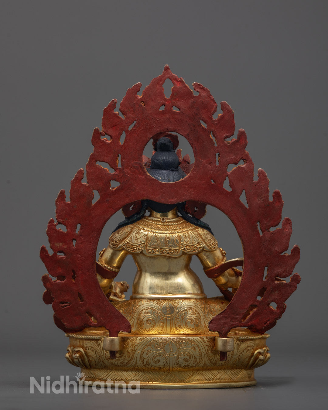 Back view of Dzambhala sculpture highlighting intricate robe and crown carvings