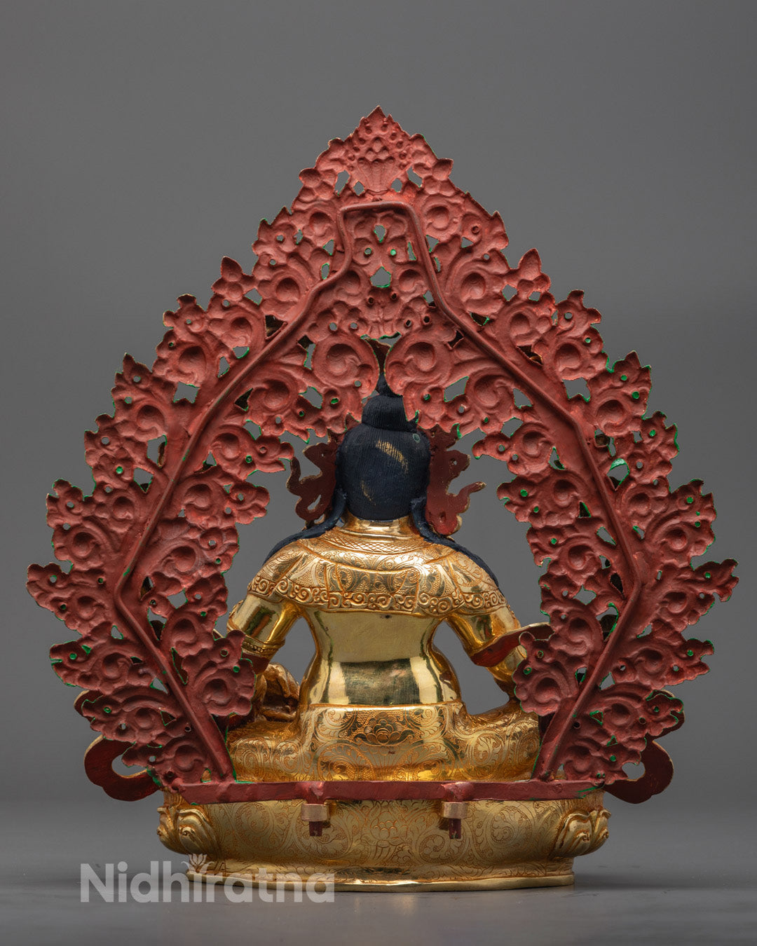 Back view of Dzambhala statue revealing intricately carved and colored halo