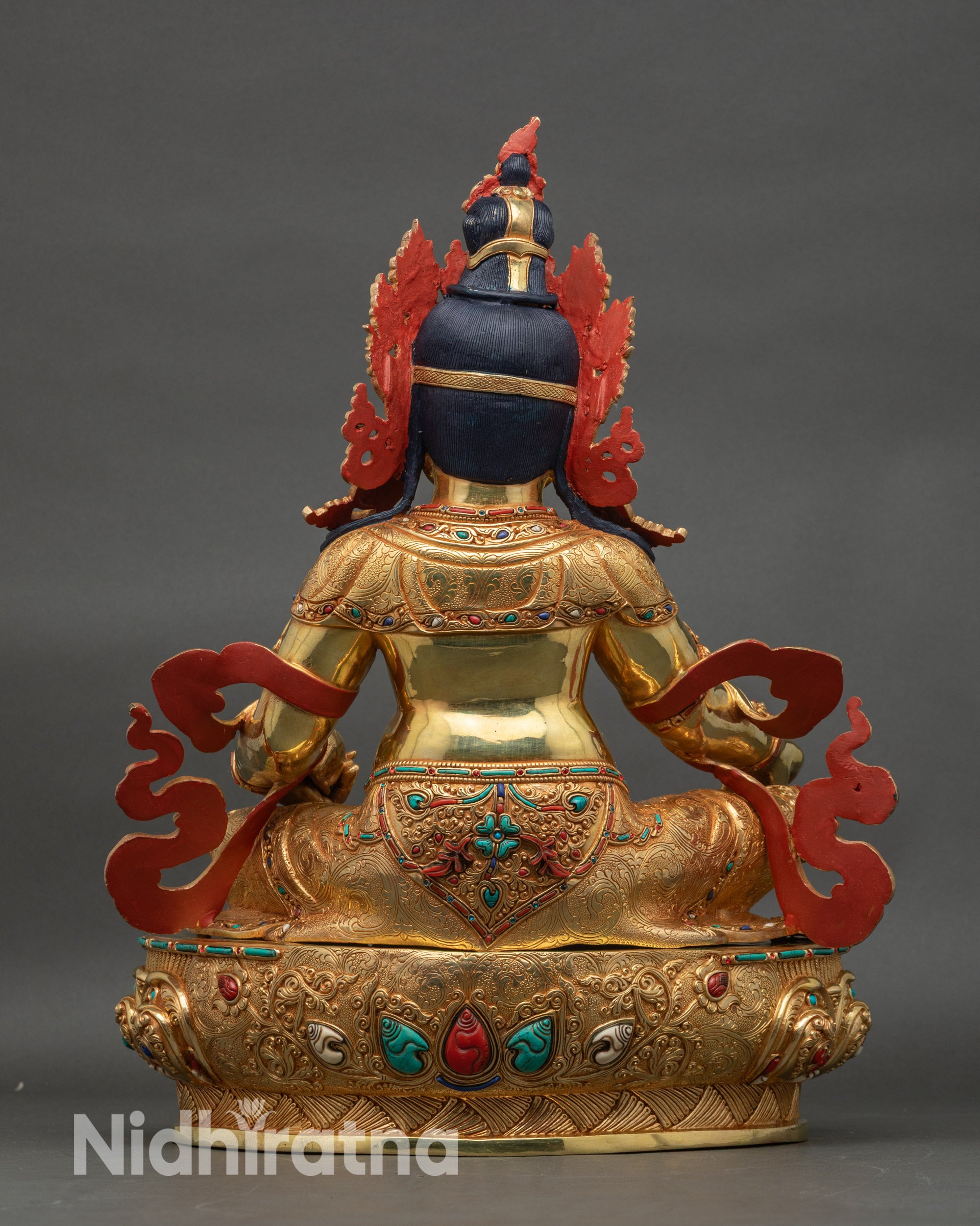 Back view of Dzambhala statue showing sculpted robe details and traditional Nepal artistry