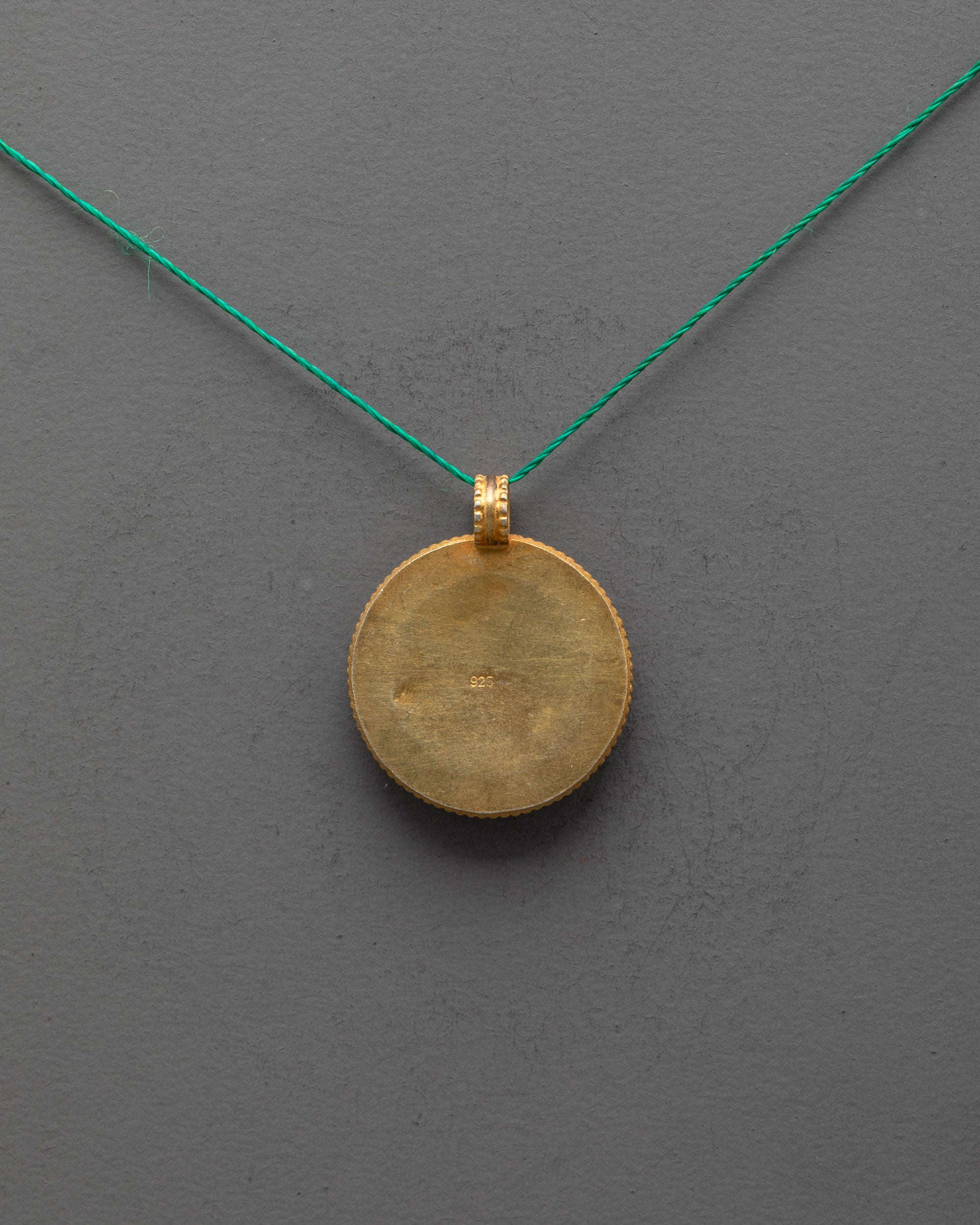 Back view of Endless Knot Locket revealing smooth copper base and artisan craftsmanship