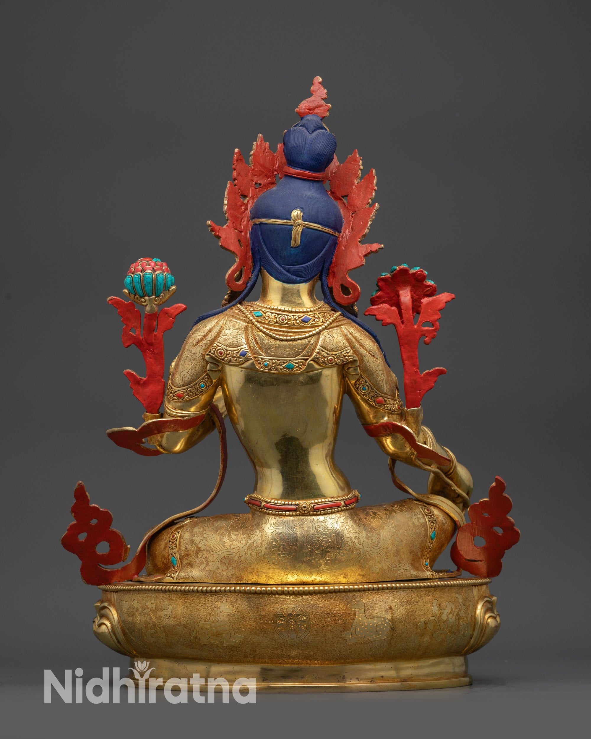 Back view of Green Tara statue showing carved robe, jewelry patterns, and lotus seat