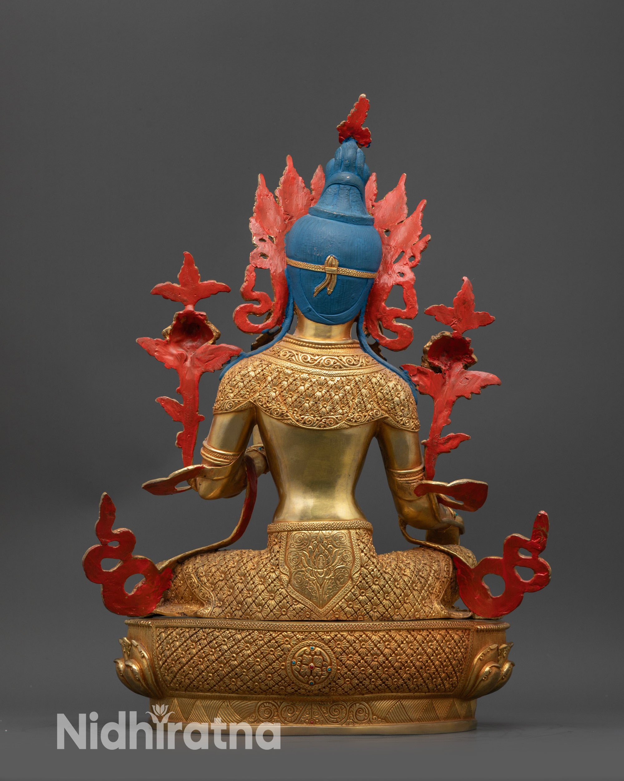 Back view of Green Tara statue showing detailed hand-carved floral and patterned garments