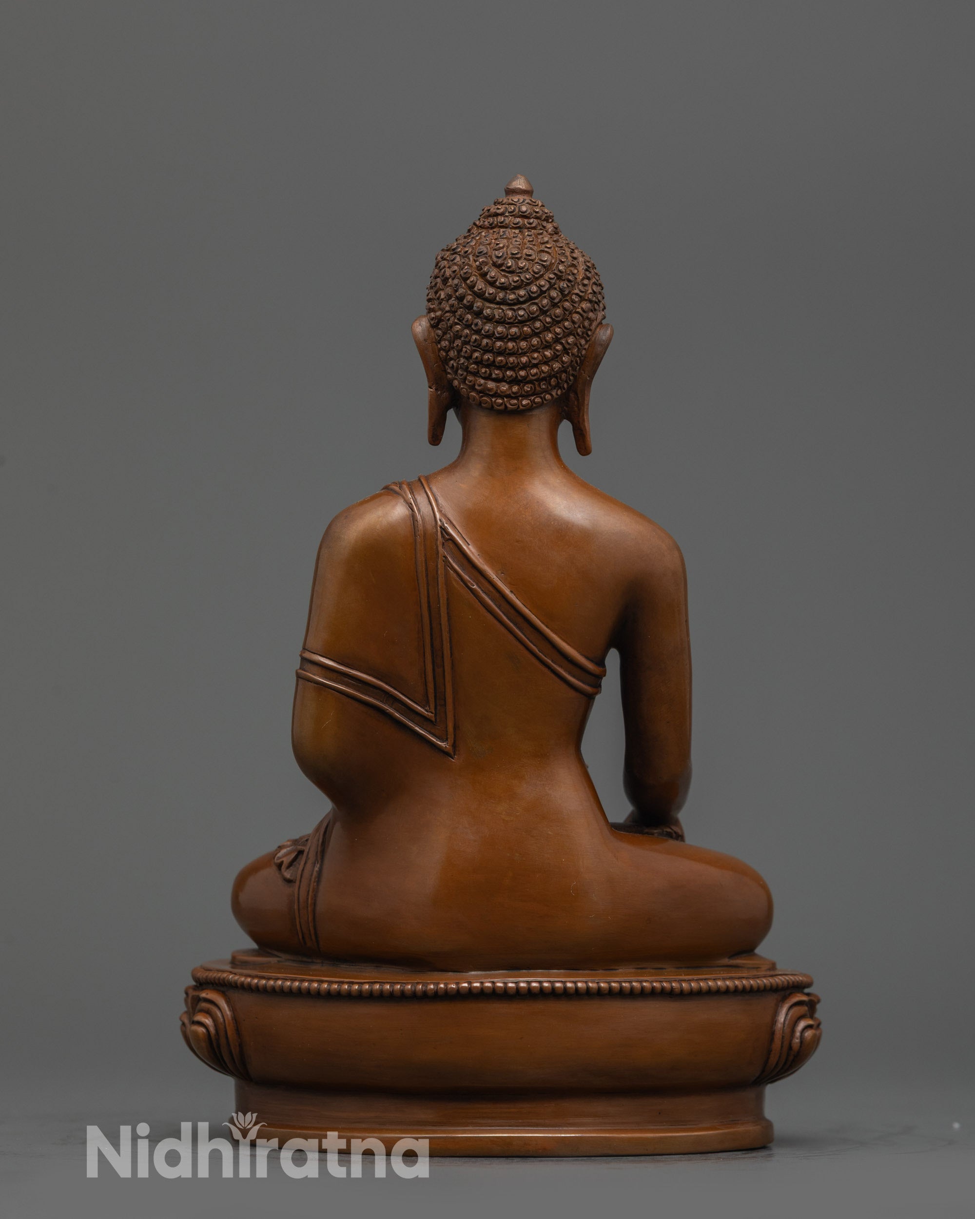 Back view of Himalayan Shakyamuni Buddha statue highlighting lotus seat and robe folds