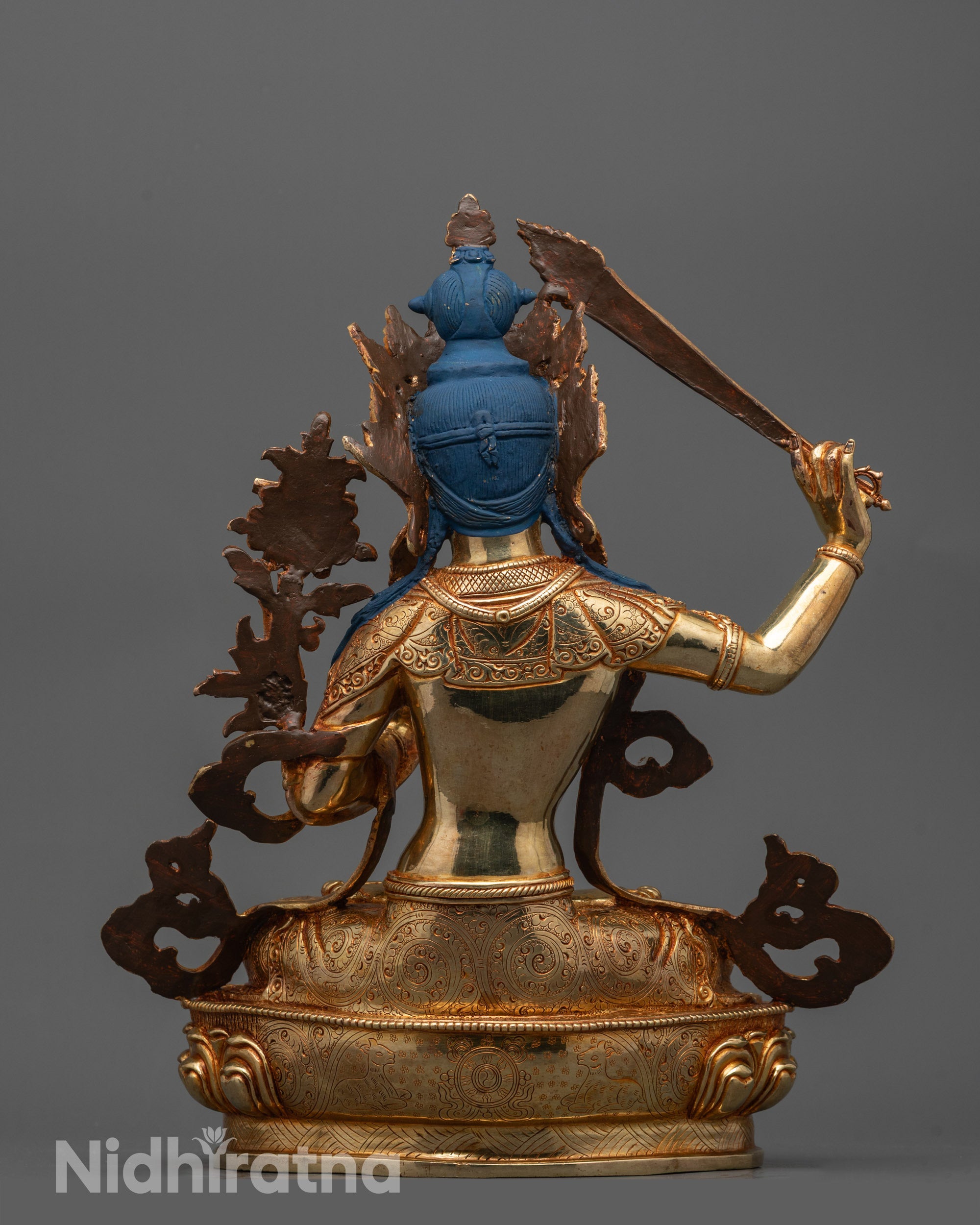Back view of Manjushri Statue in meditative pose with radiant gold gilding