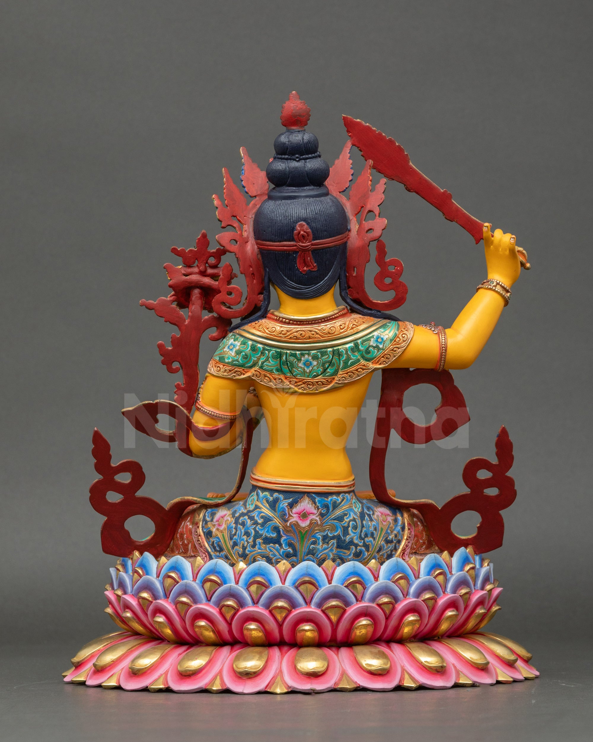 Back view of Manjushri statue showing flowing robes and multi-layered lotus pedestal