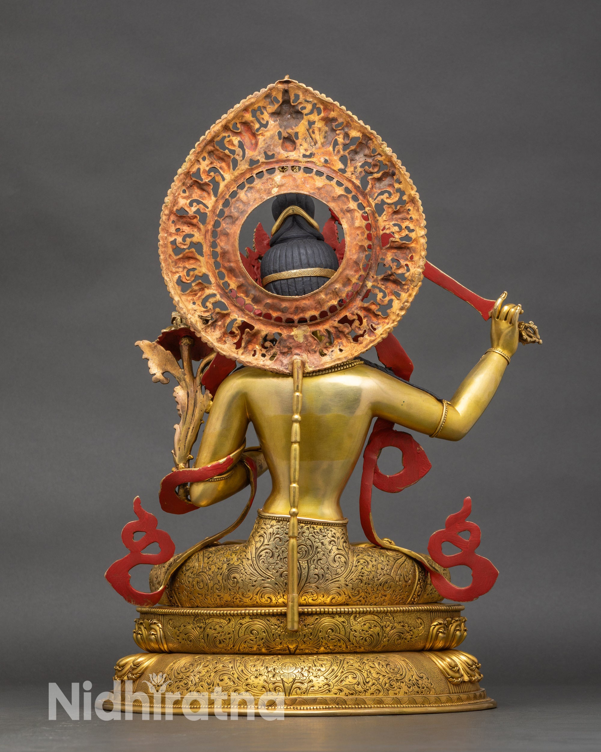 Back view of Manjushri statue, showing swirling robe patterns and lotus seat