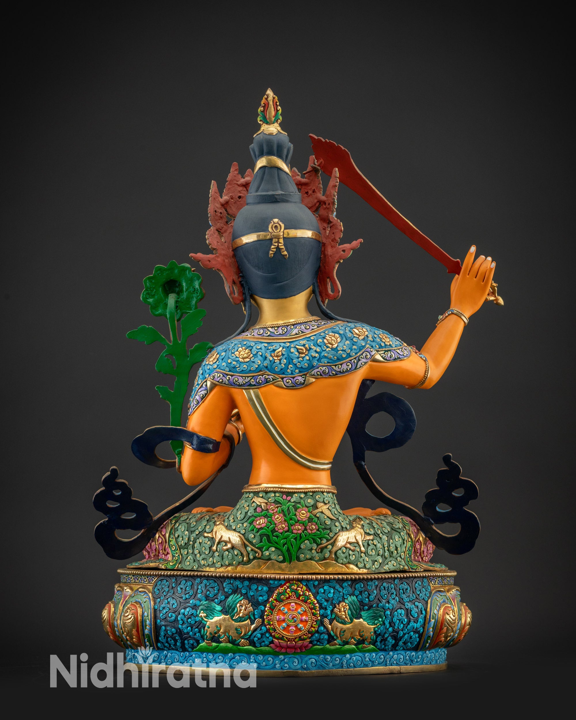 Back view of Manjushri statue with gold-plated robes and carved lotus base