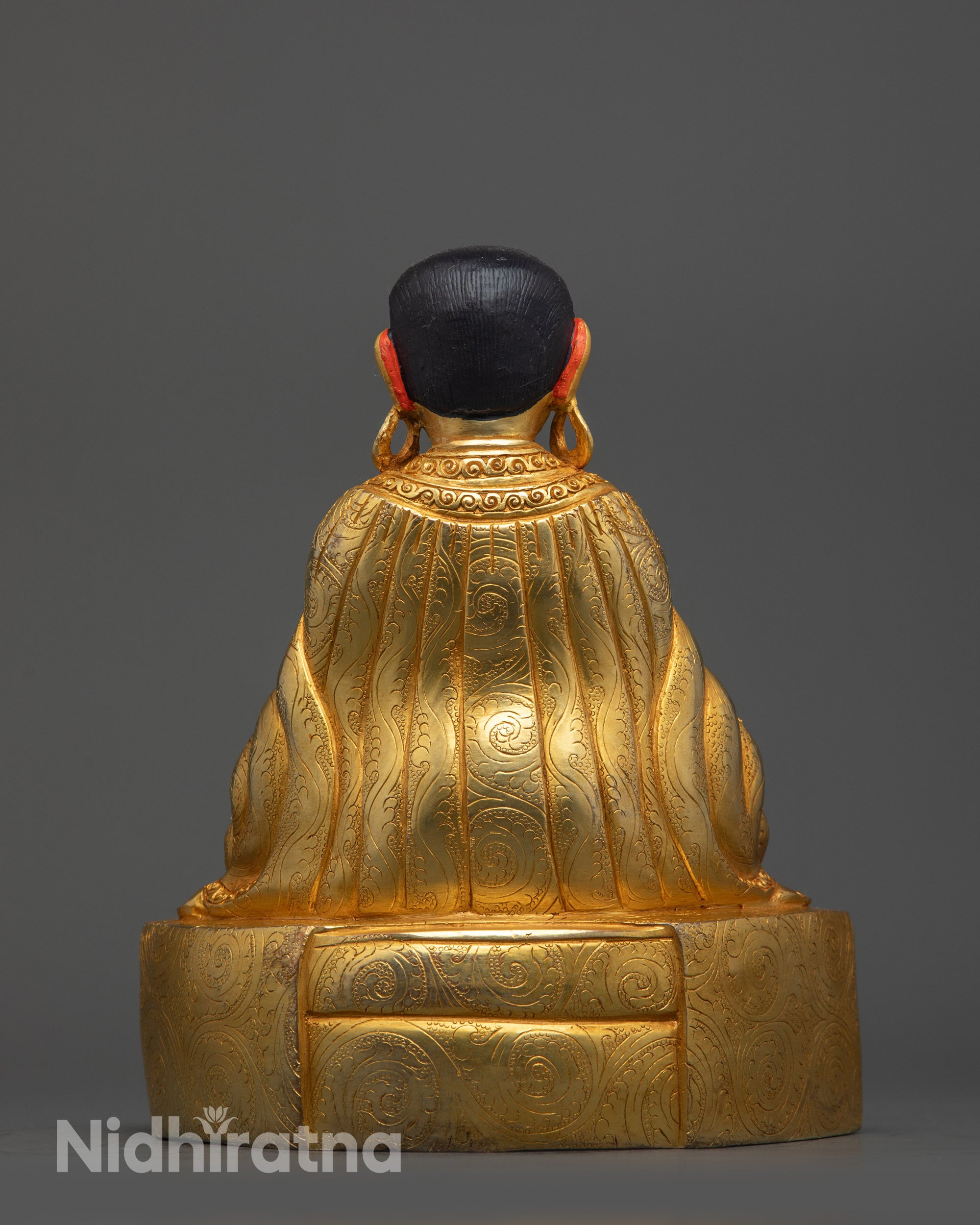 Back view of Marpa Statue with detailed robe patterns and gold fire-gilded body