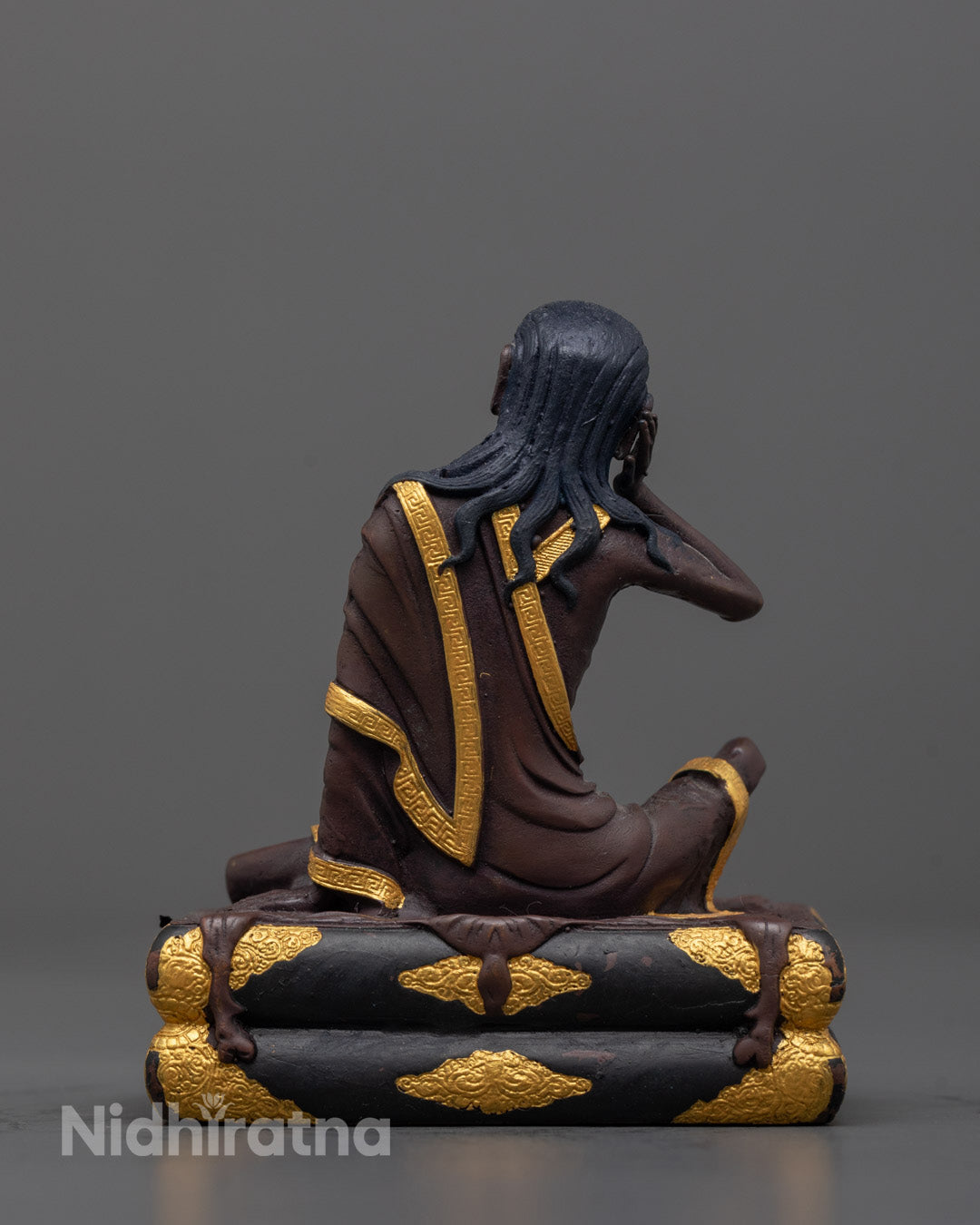 Back view of Milarepa statue highlighting gold plating and carved spiritual details