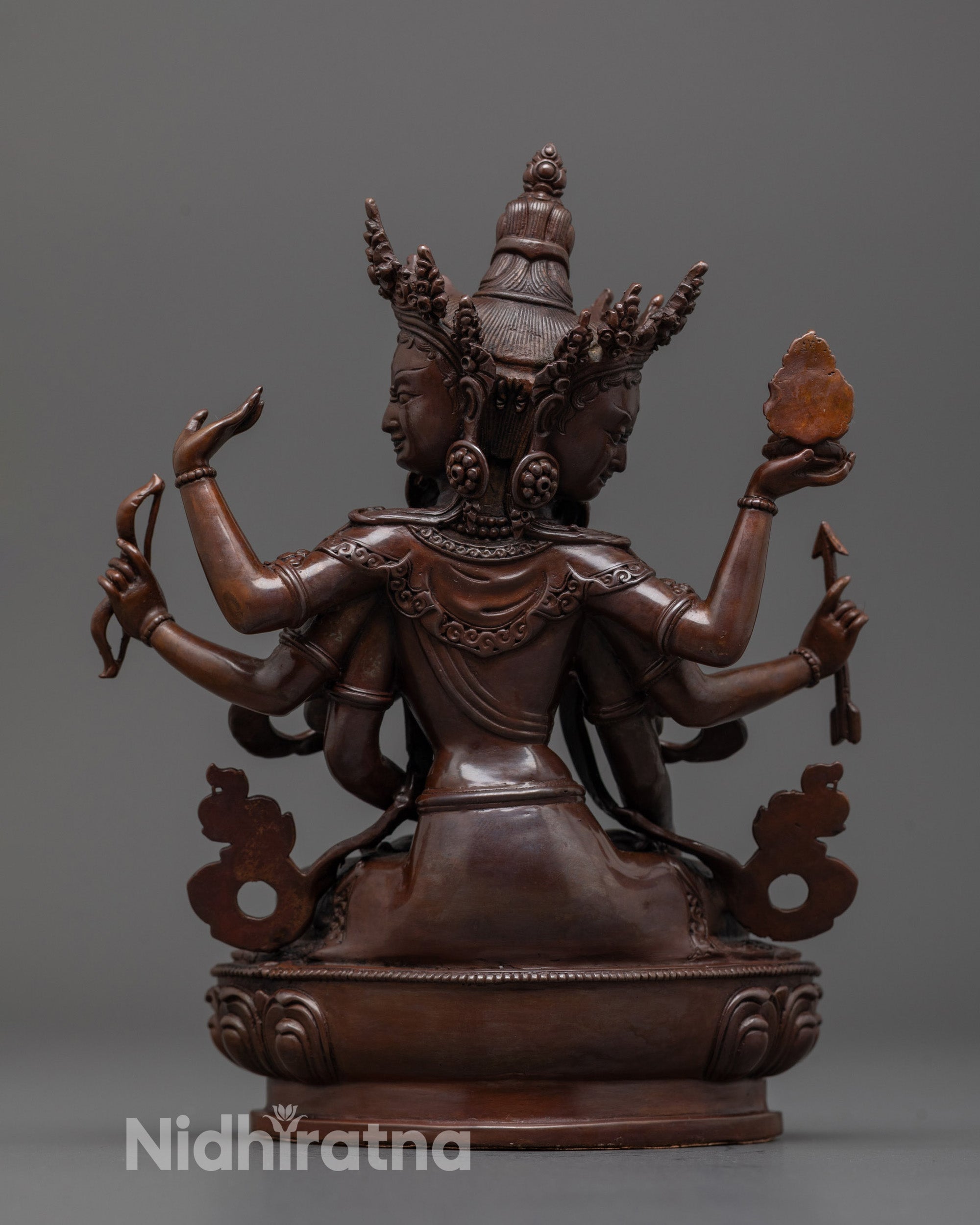 Back view of Namgyalma statue revealing oxidized copper texture and lotus base detail