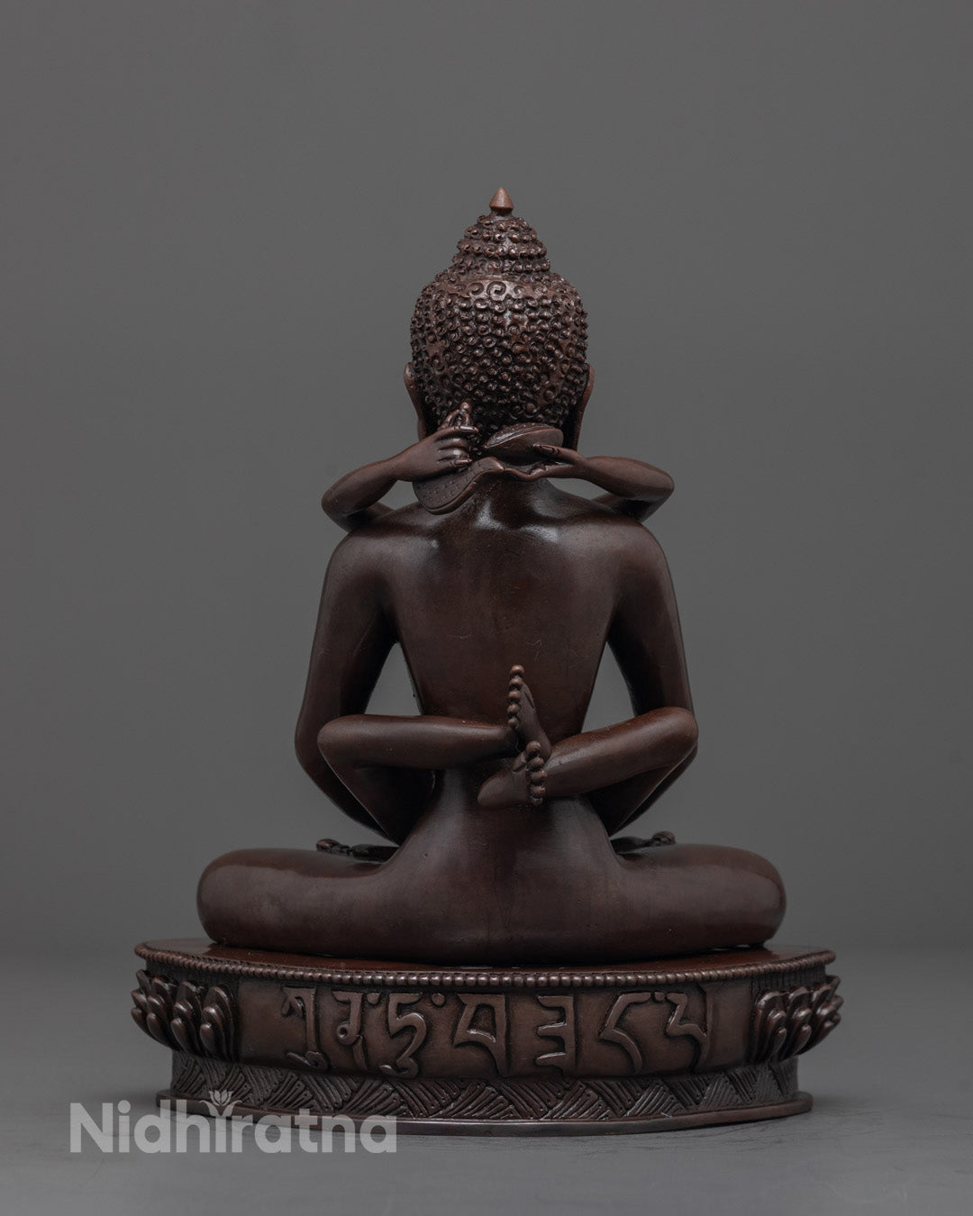 Back view of Oxidized Jambhala Statue highlighting copper body and mantra hollow